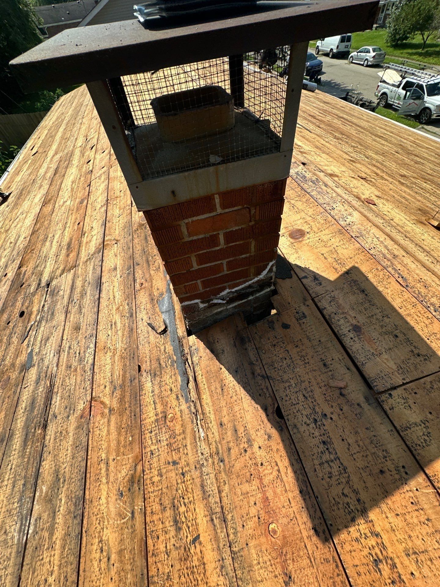 Rot and old patching around the faux chimney on the bare board deck, Fairborn, Ohio.
