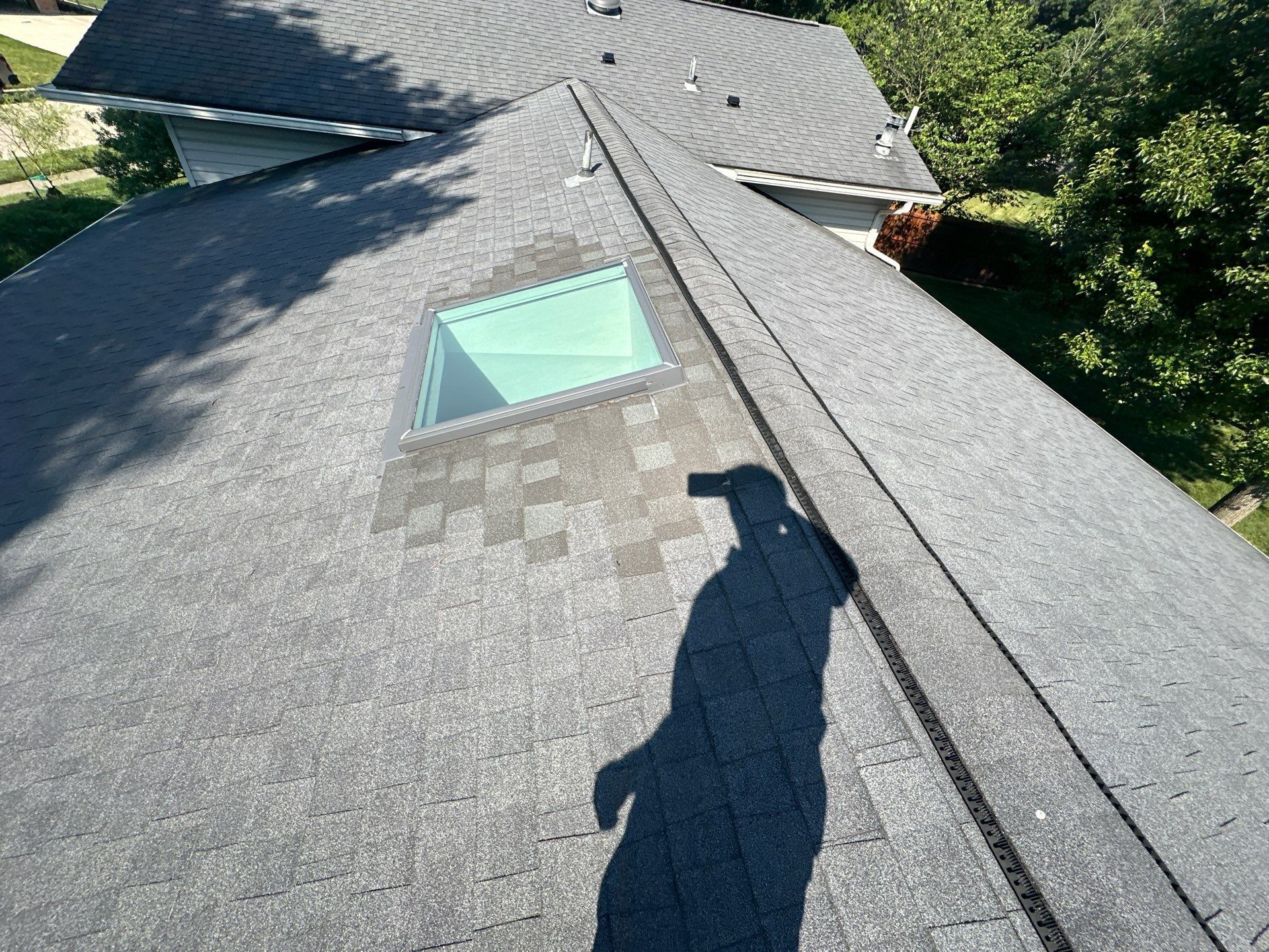 Patched shingles around the skylight below the ridge vent, Kettering, Ohio.