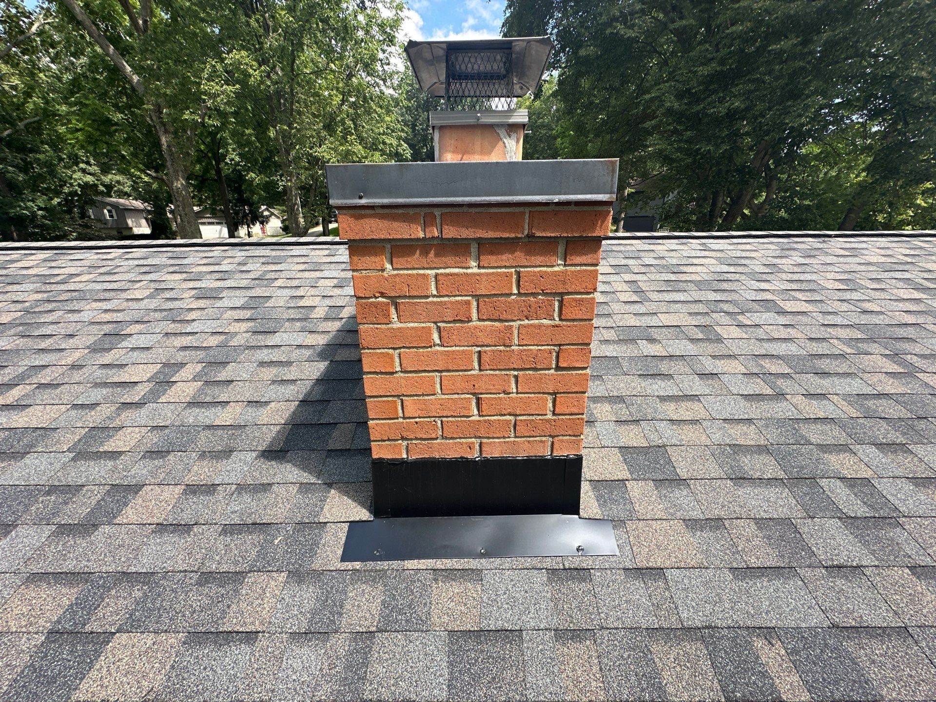 Brick chimney, black flashing and apron