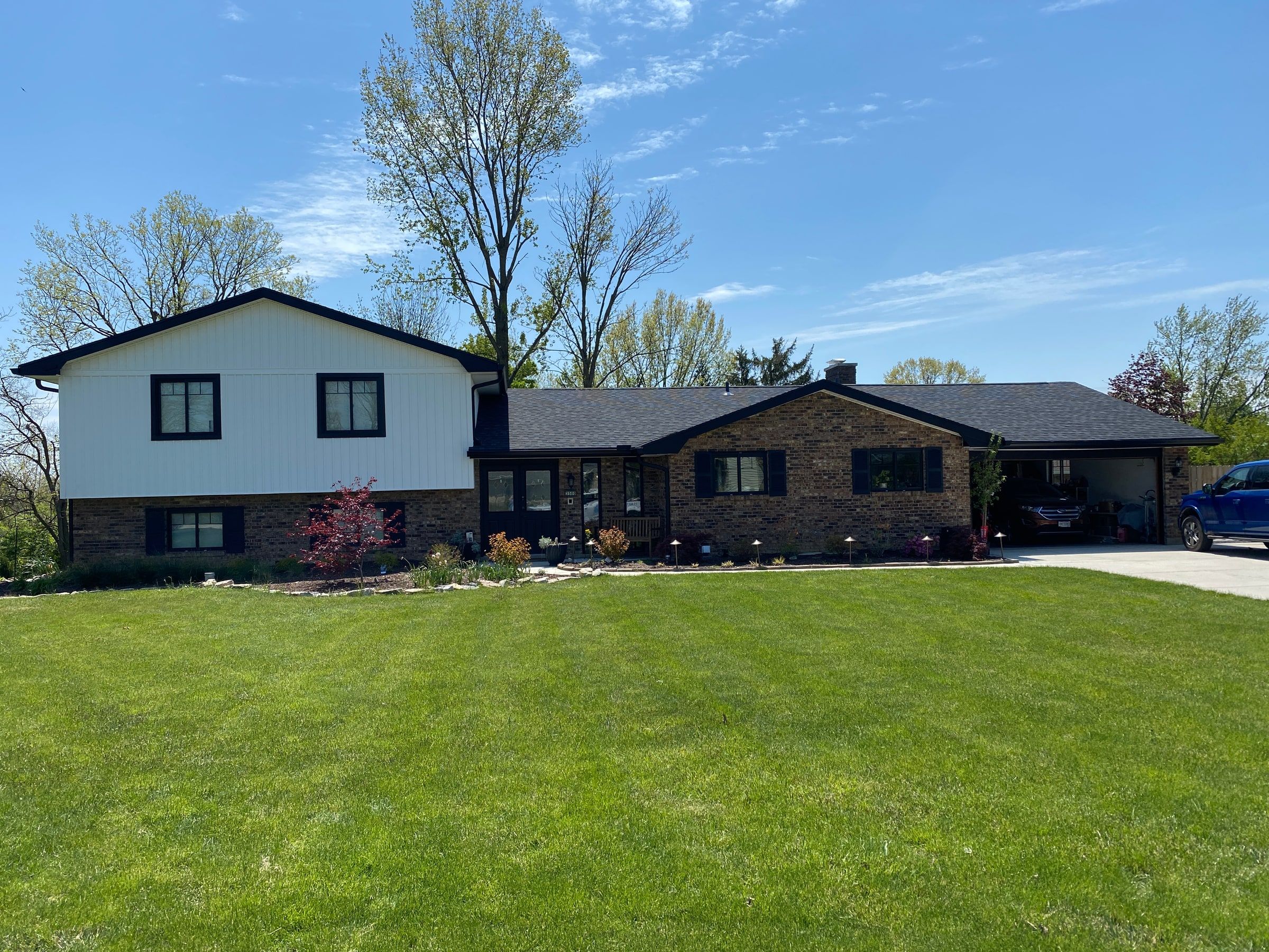 The finished house from the front lawn, the upper story in white board-and-batten siding above the brick, Beavercreek, Ohio.