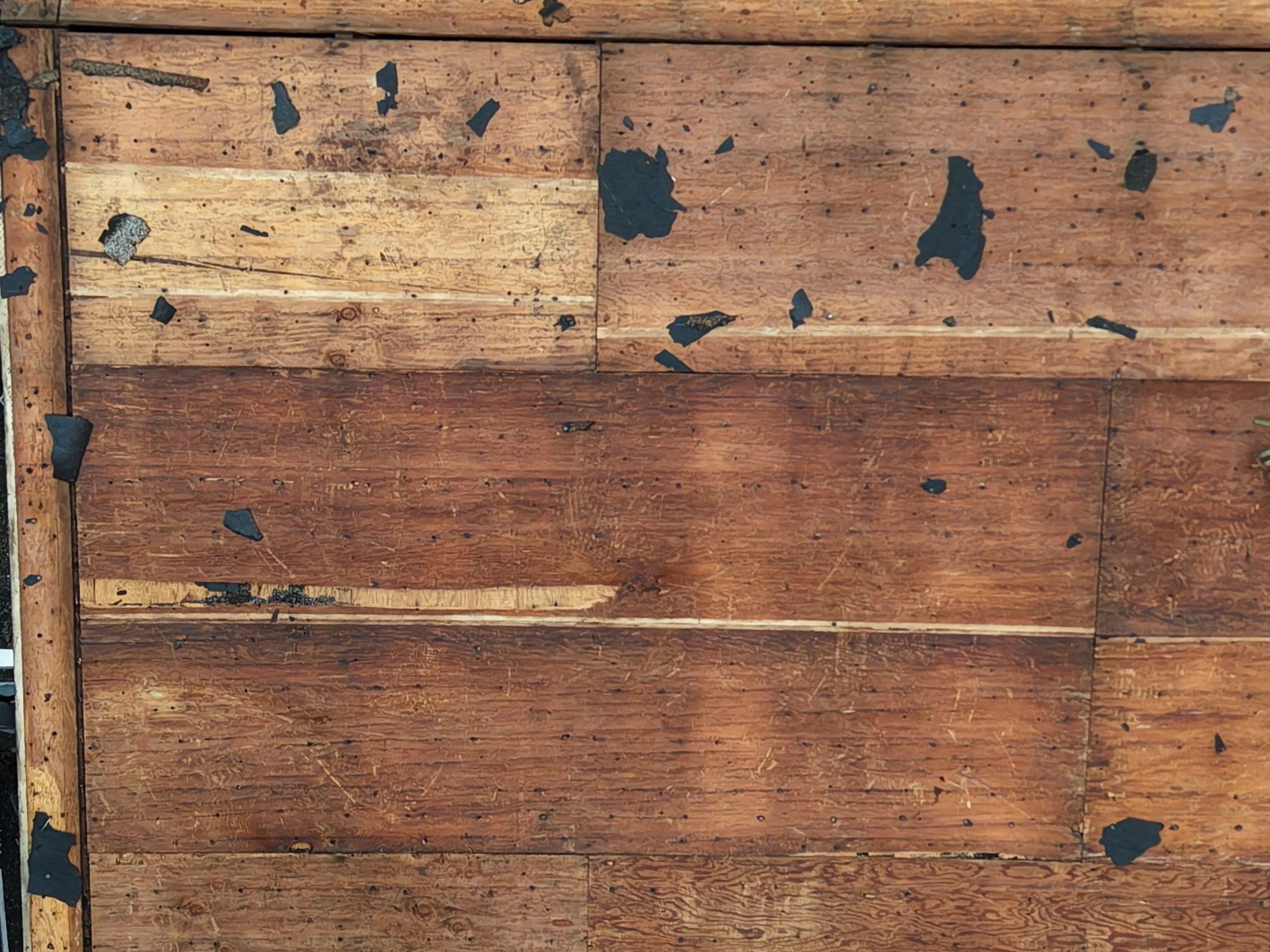 The old plywood deck after tear-off, its surface layers pulling away, Dayton, Ohio.
