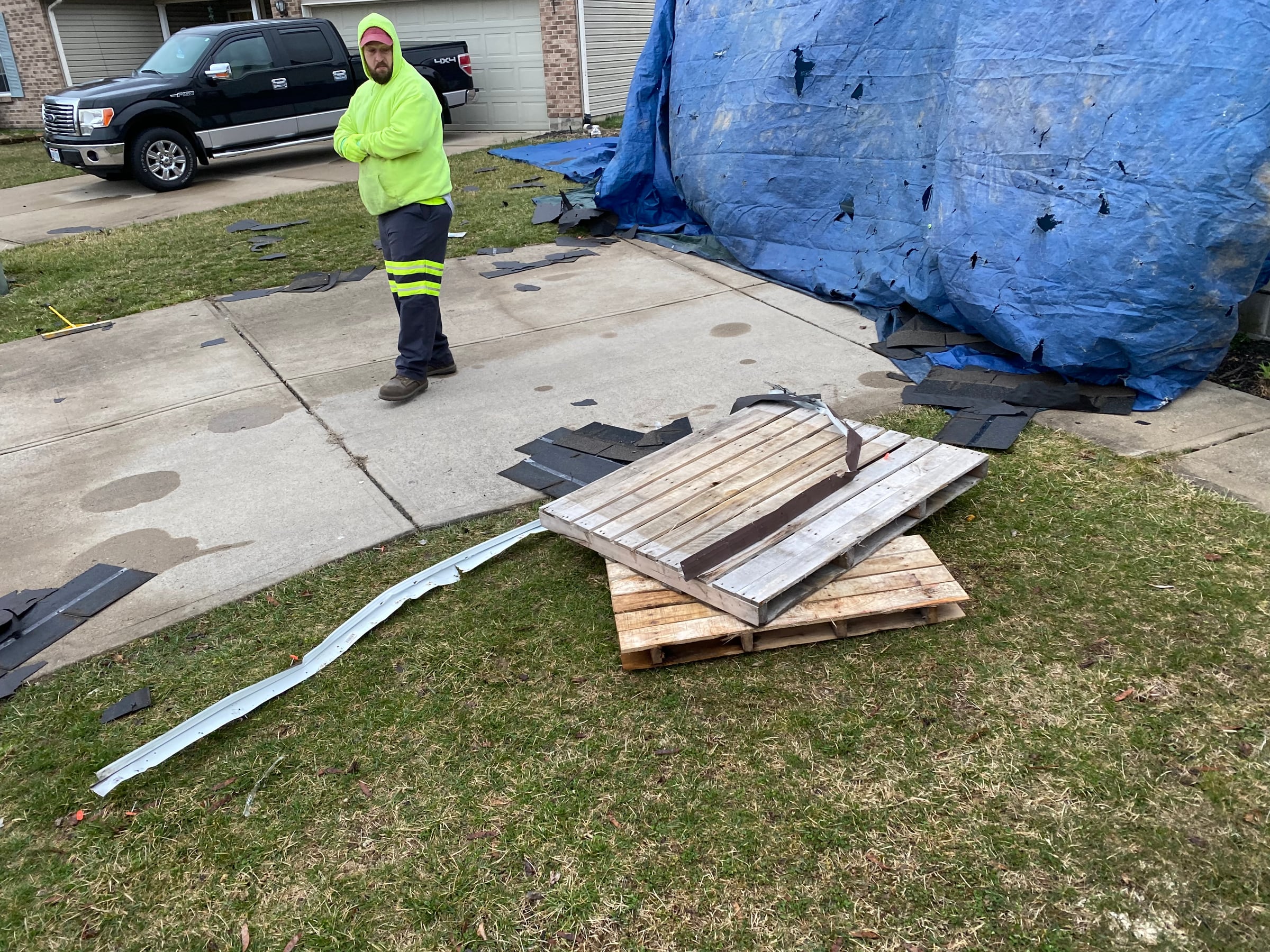 Worker, drive tarps and shingle debris