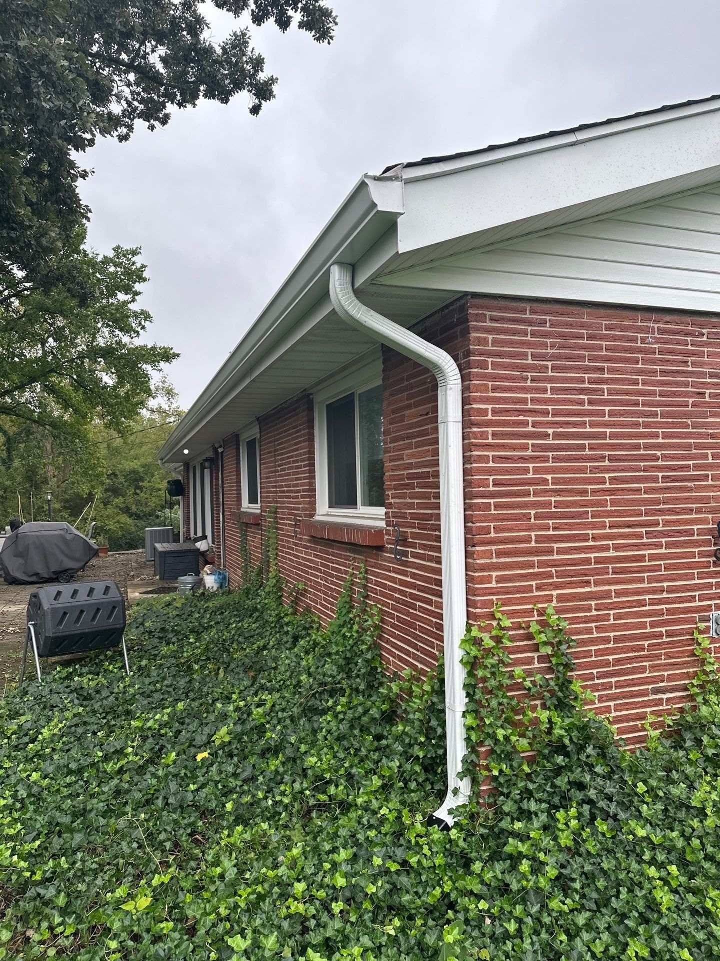 A new gutter and downspout at a brick corner above the ivy, West Carrollton, Ohio.