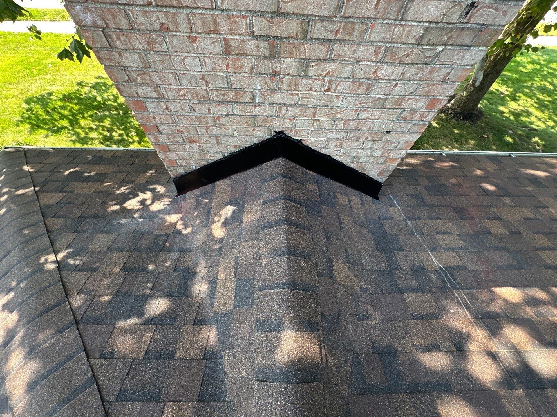 New chimney flashing and shingles around the front of the brick chimney, Dayton, Ohio.