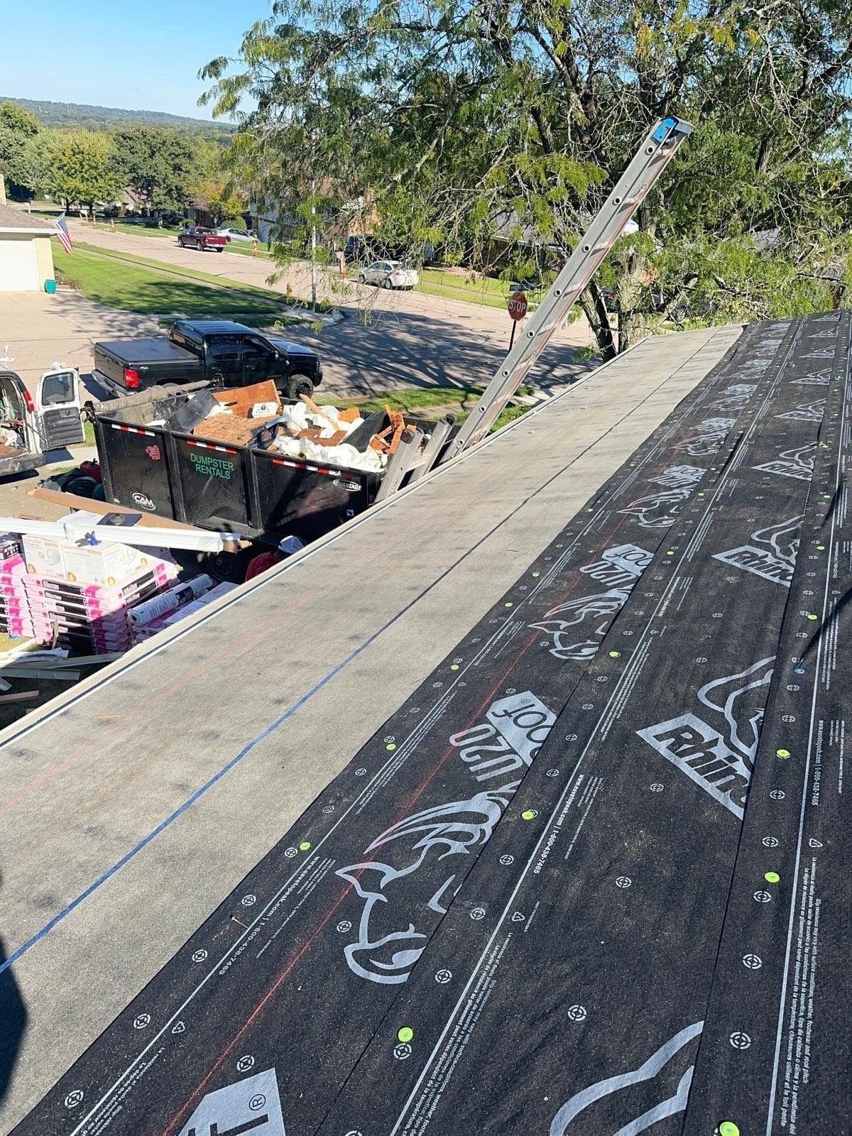 Underlayment along the ridge, with the dumpster and pallets below, West Carrollton, Ohio.