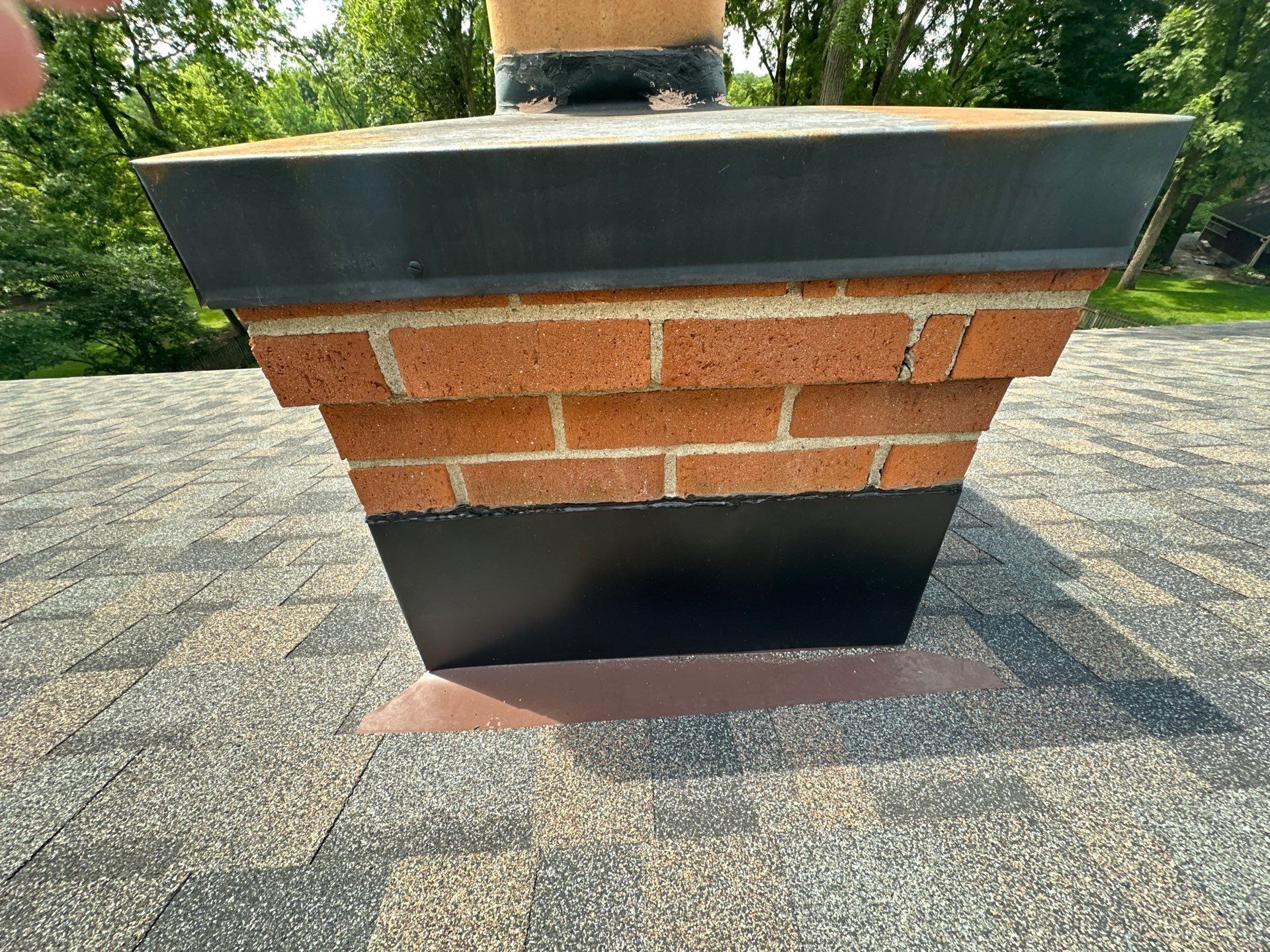 Brick chimney, metal cap and black flashing