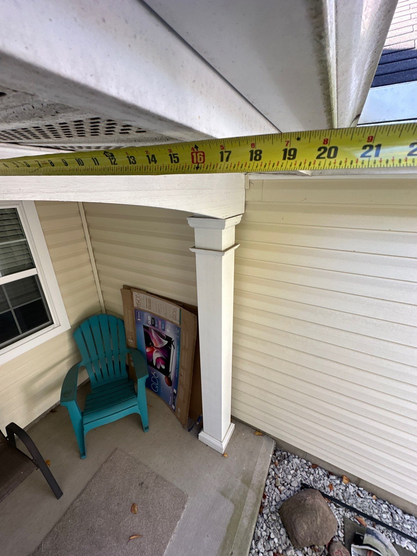 A tape measure under the soffit, measuring the overhang above the front porch, Beavercreek, Ohio.