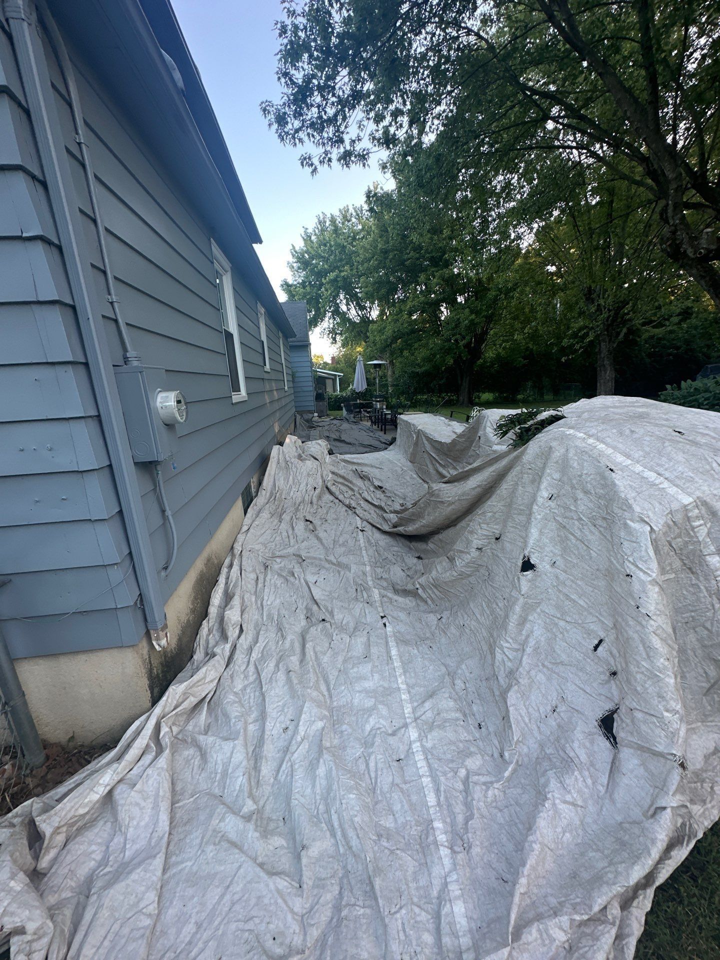 A tarp along the foundation down the side of the house, Beavercreek, Ohio.