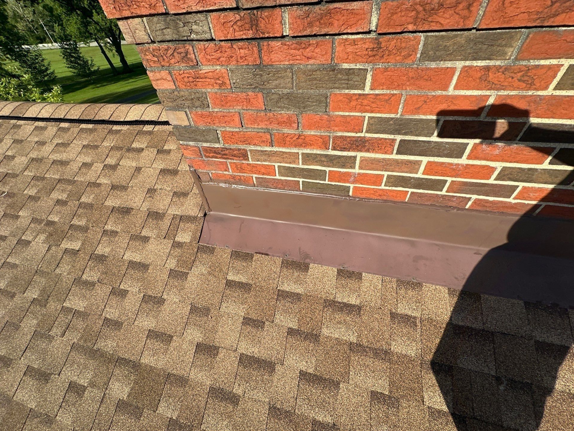 Flashing along the side of the brick chimney on the new shingles, Clayton, Ohio.