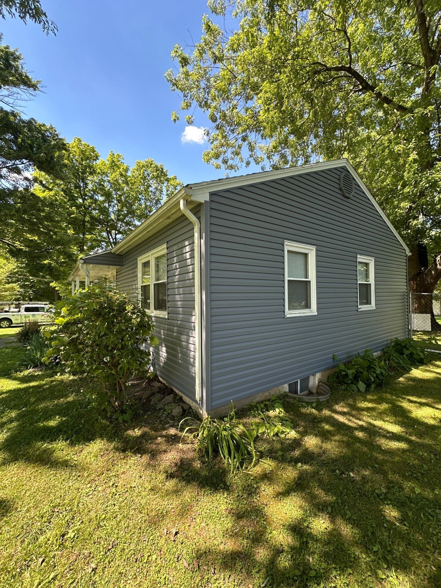 The corner of the house in new siding behind the shrubs, Beavercreek, Ohio.