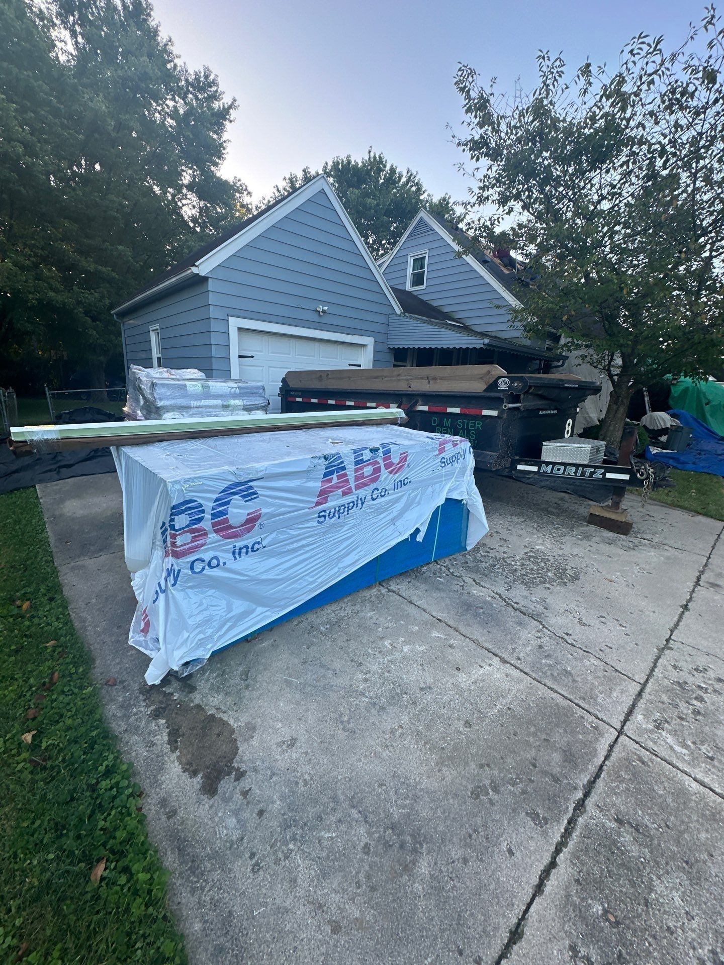 Shingle bundles under a wrap on the driveway beside the trailer, Beavercreek, Ohio.
