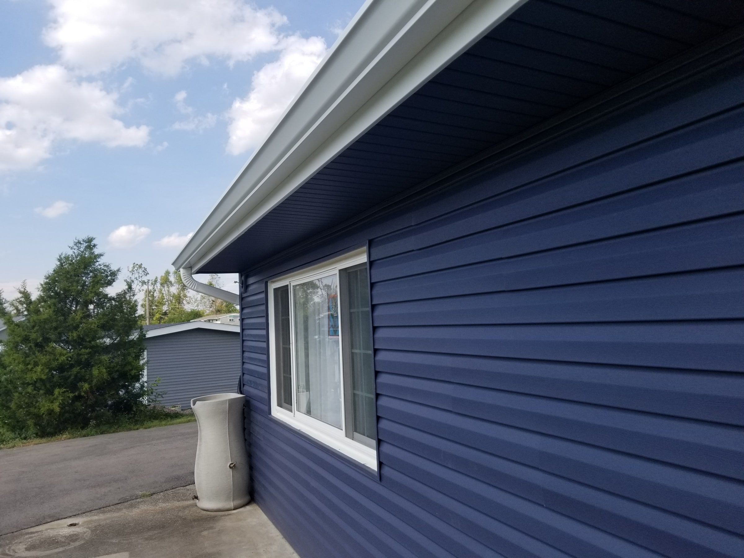 New blue siding and a white gutter along the back of the house, Beavercreek, Ohio.