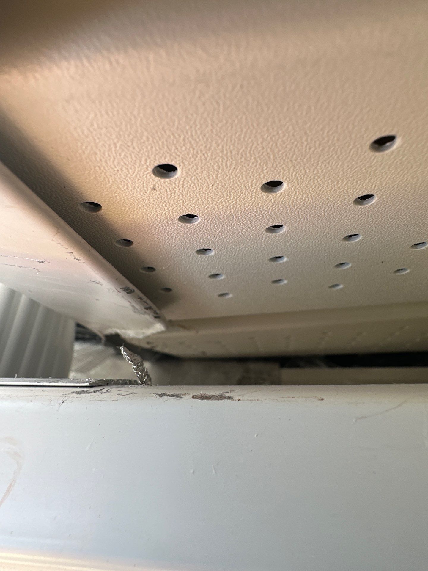 Vented soffit panel above the gutter
