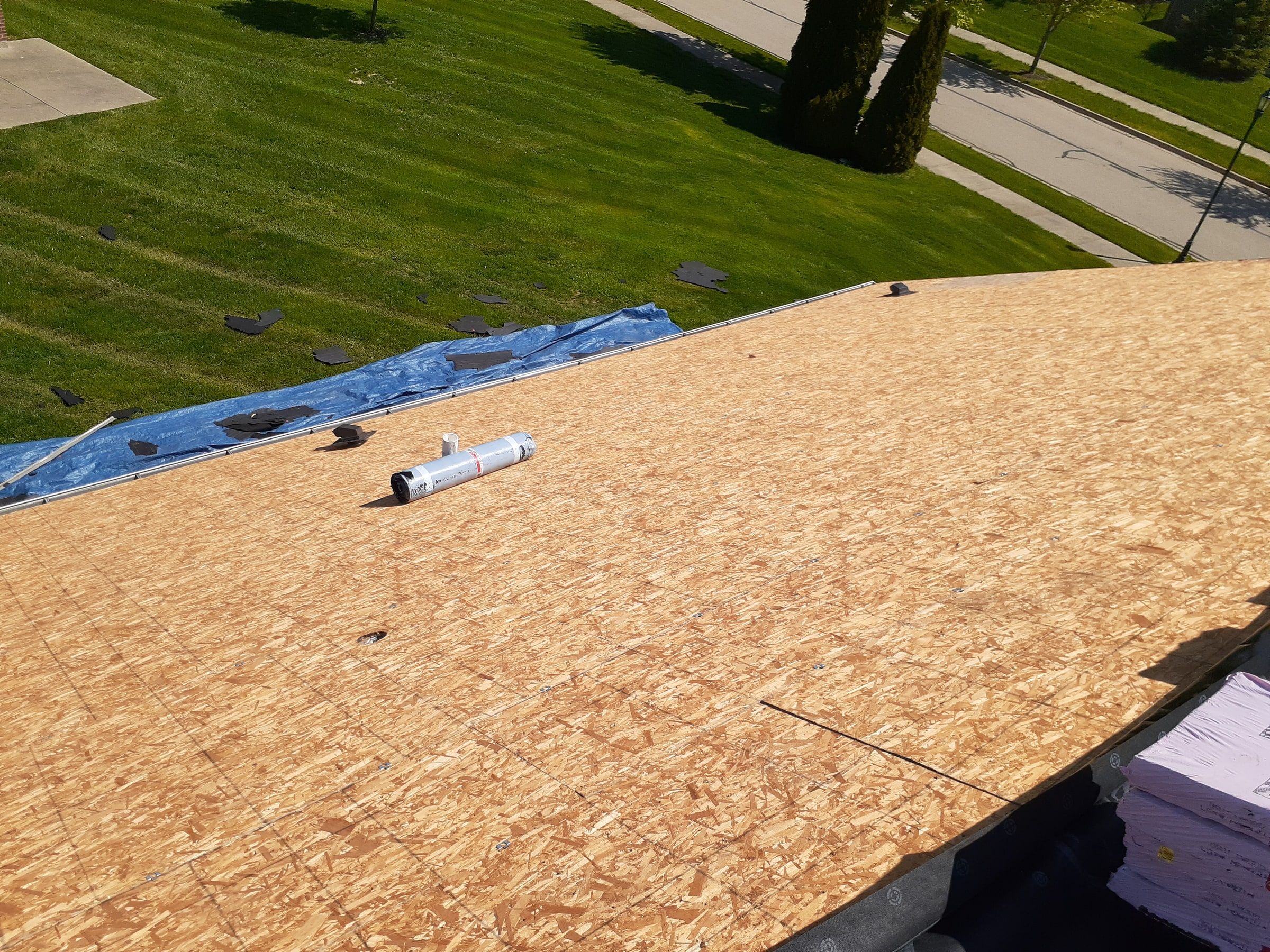 A stripped OSB slope with a roll of underlayment on it, Xenia, Ohio.