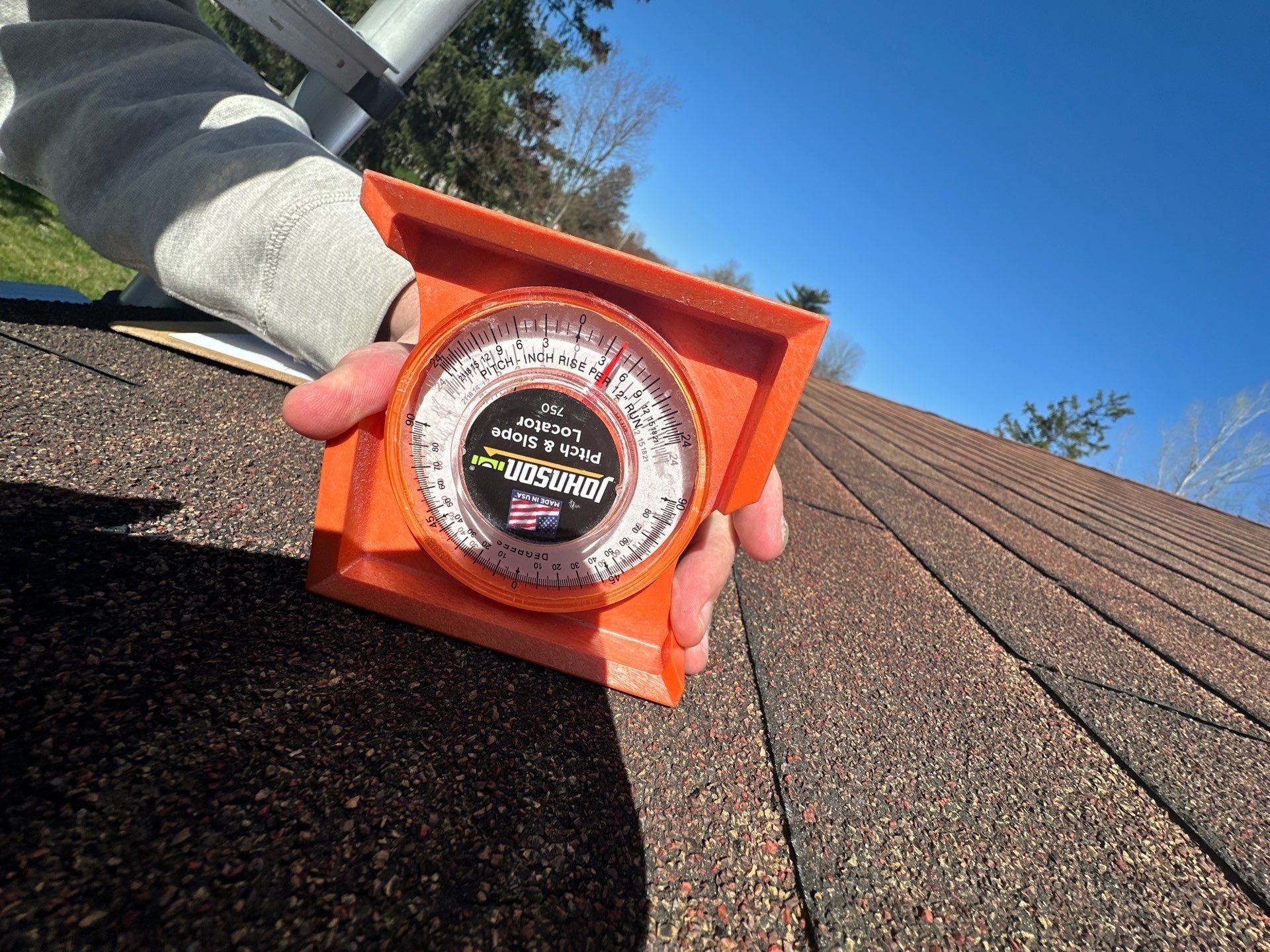 Pitch gauge held on the old shingles to read the roof slope, Beavercreek, Ohio.