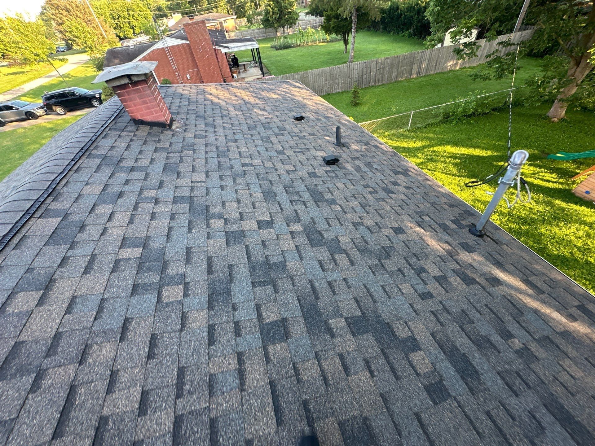 Brick chimney sealed into the new shingles on the finished roof, Beavercreek, Ohio.