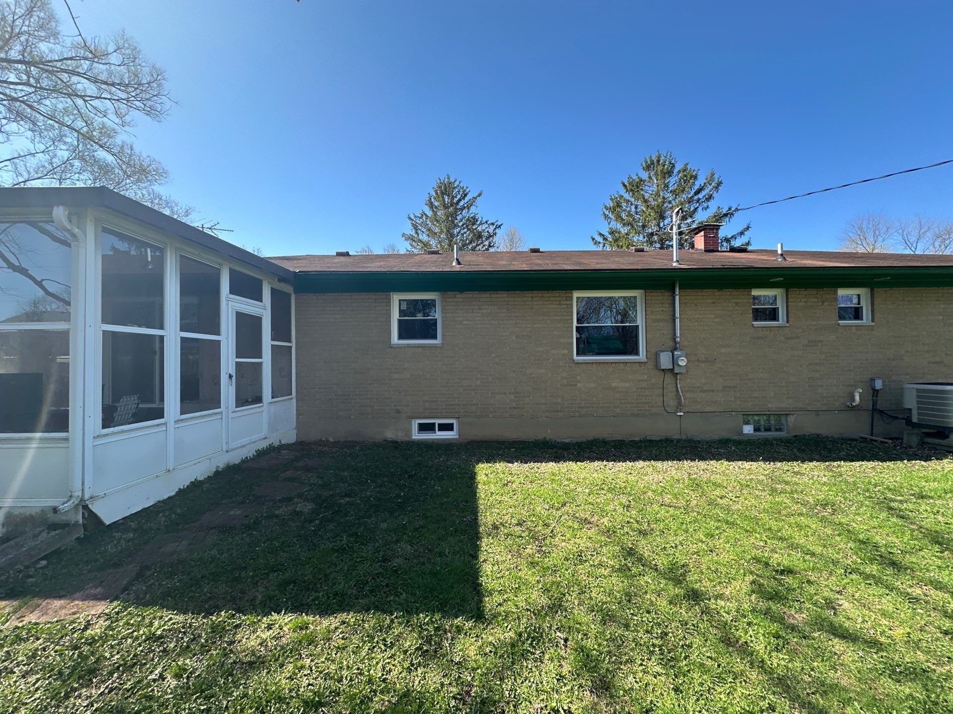 Back of the house and sunroom with the old roof line in spring, Beavercreek, Ohio.