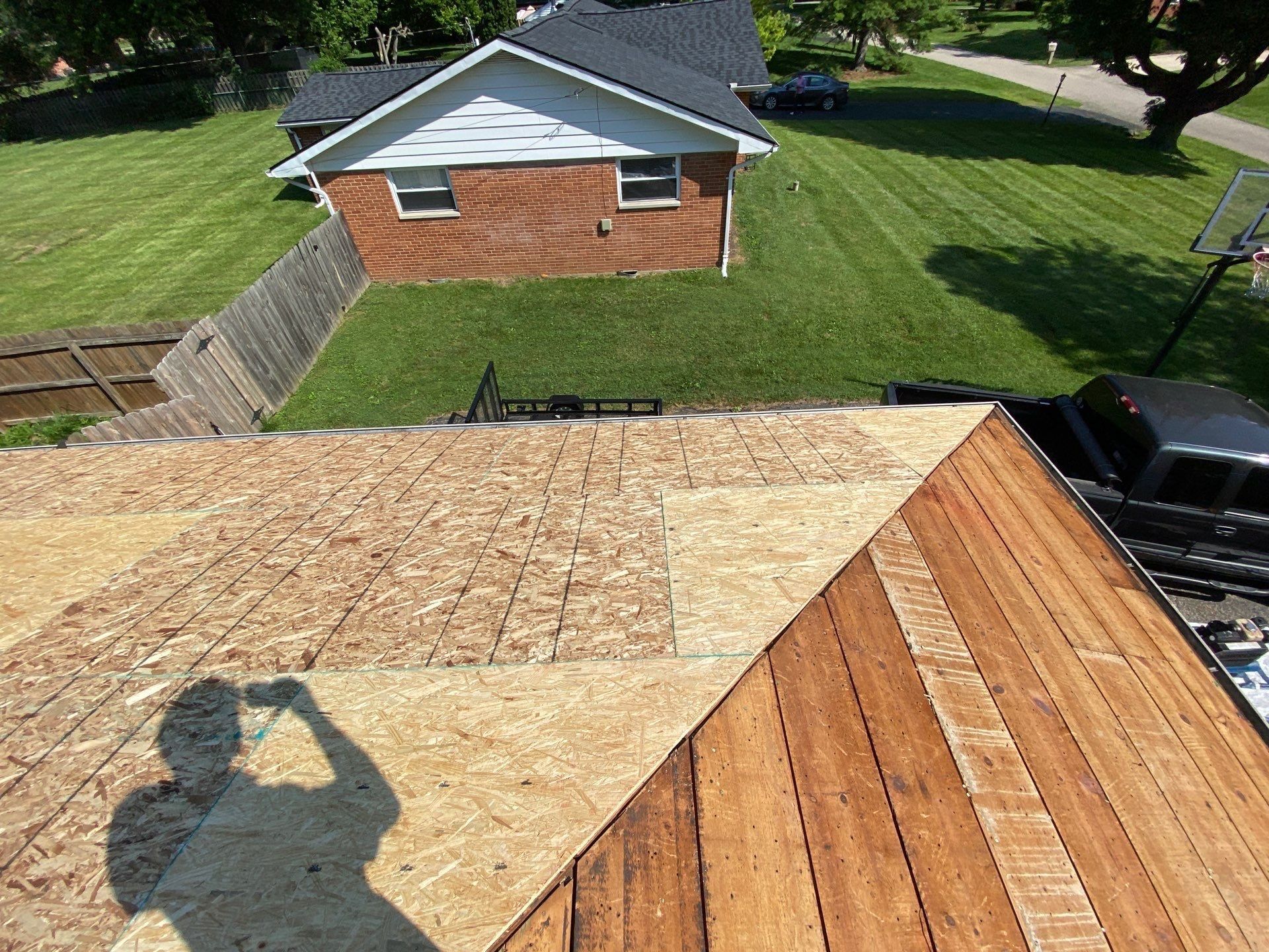 New sheathing covering one hip slope beside the remaining old planks, Beavercreek, Ohio.
