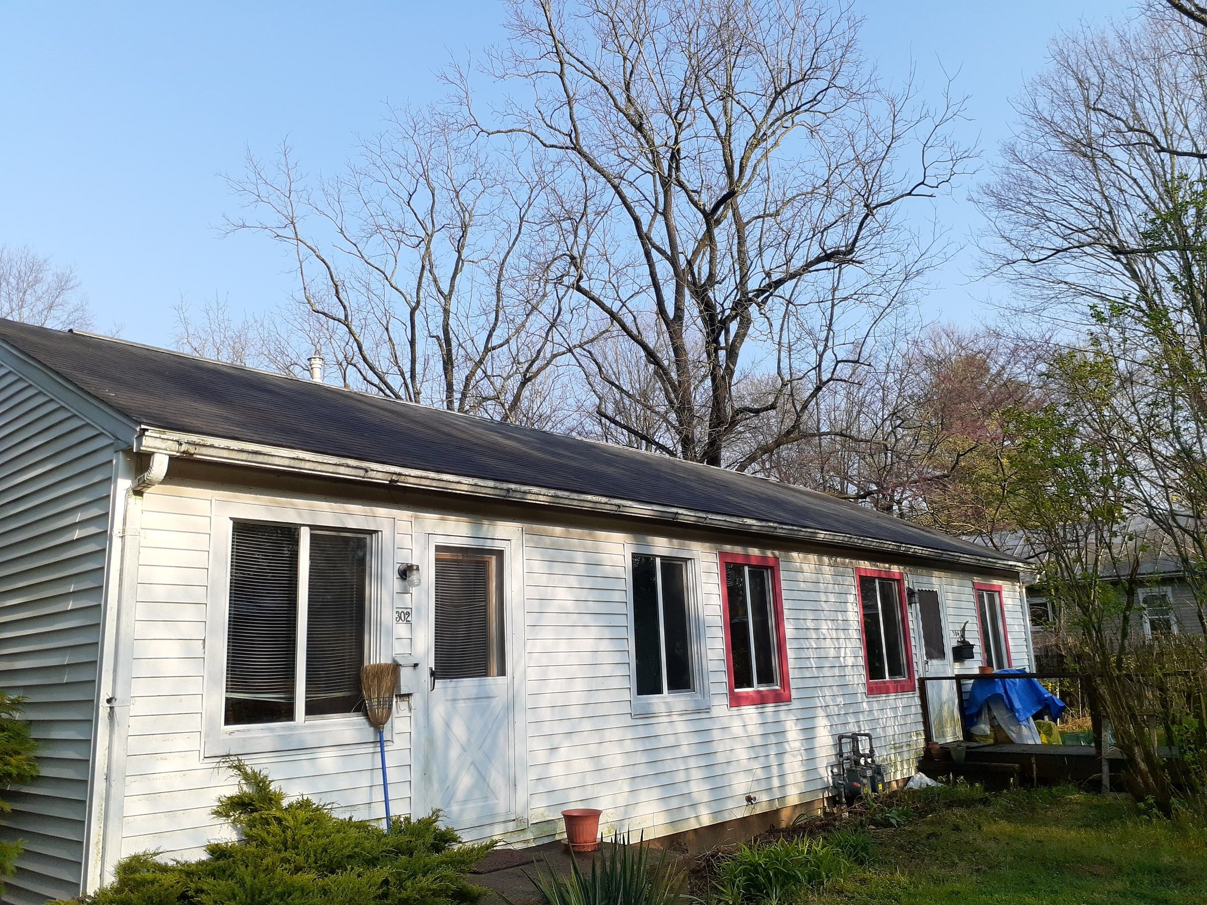 The long side of the ranch with its old shingles, red window trim and a small deck, Yellow Springs, Ohio.