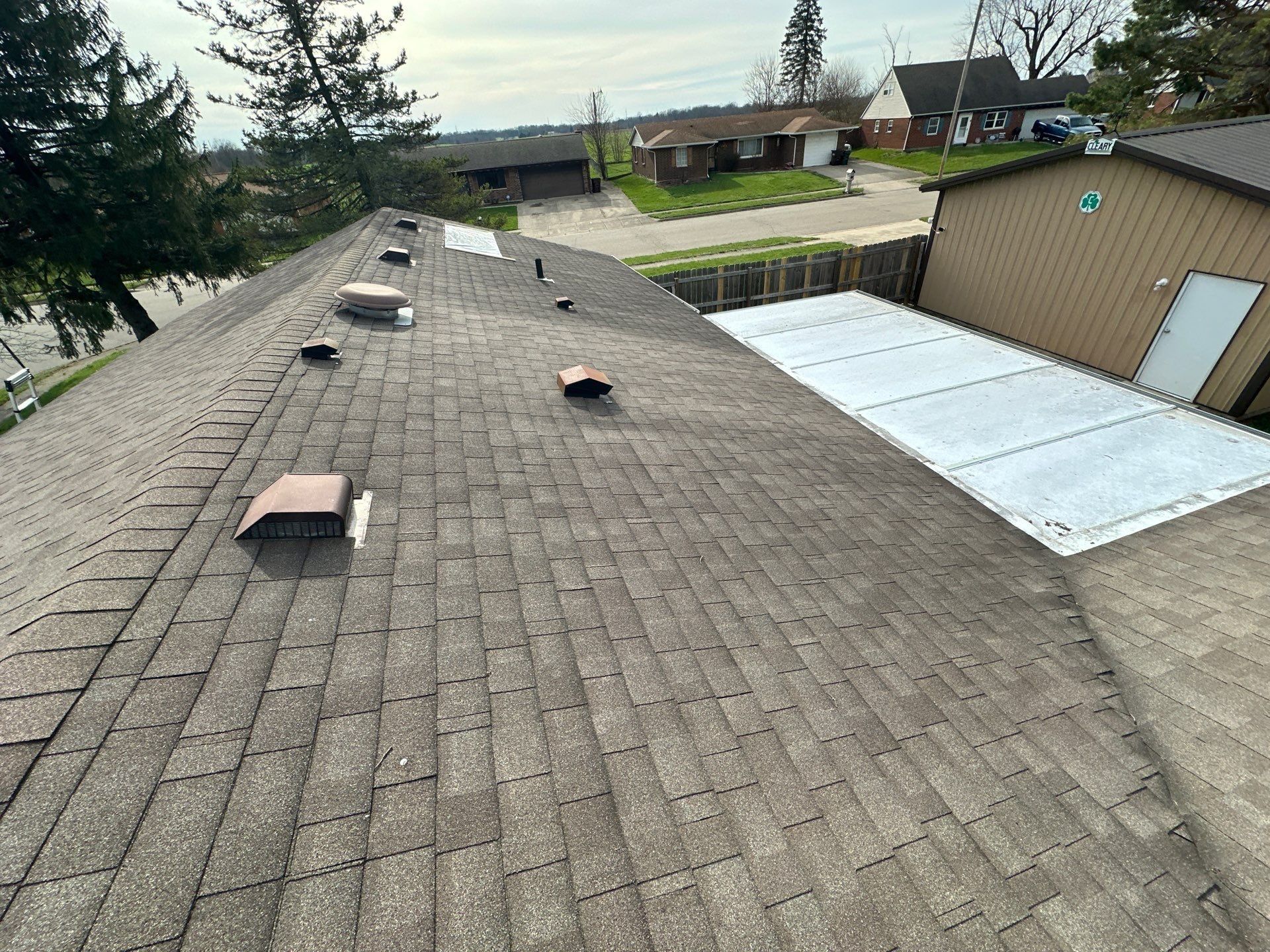 An Arrowhead Acres roof seen from the ridge, with its vents and the street beyond, Xenia, Ohio.