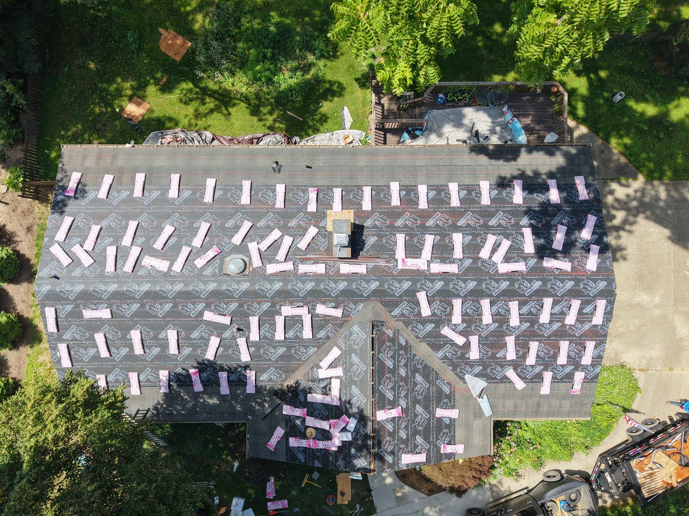 The whole roof in underlayment with shingle bundles staged across it, from above, Beavercreek, Ohio.