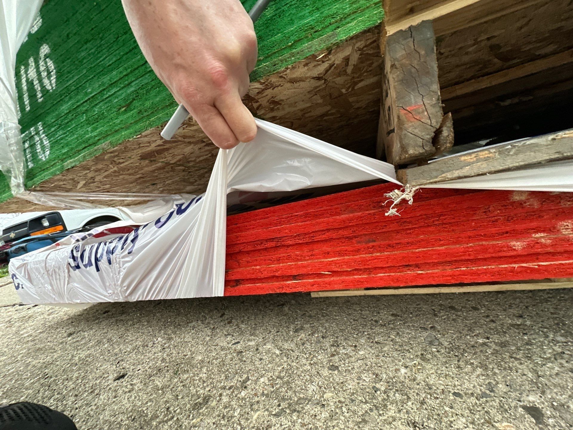 Sheathing and red-painted lumber under wrap