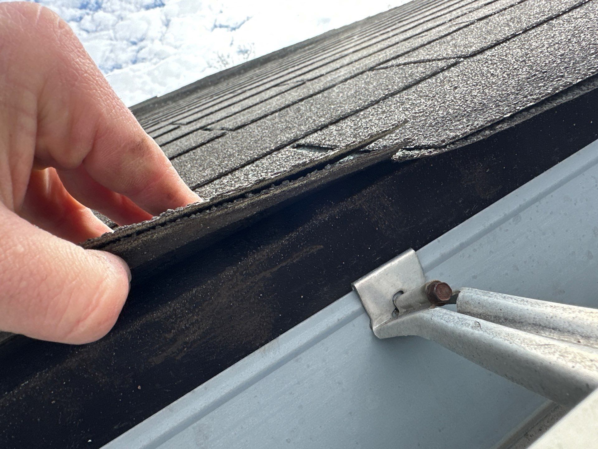 Shingle edge held clear of the gutter line