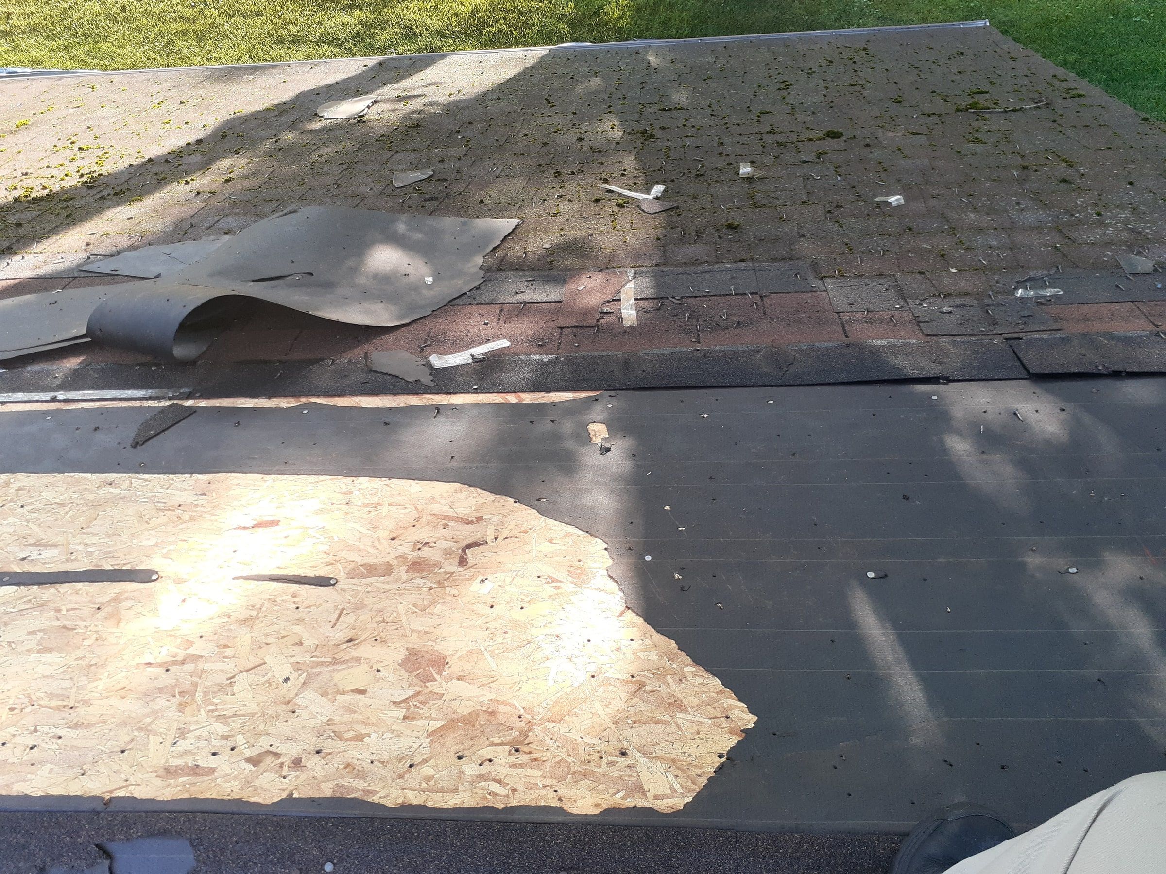 Old shingles and underlayment peeled back to reveal the wood deck, Jamestown, Ohio.