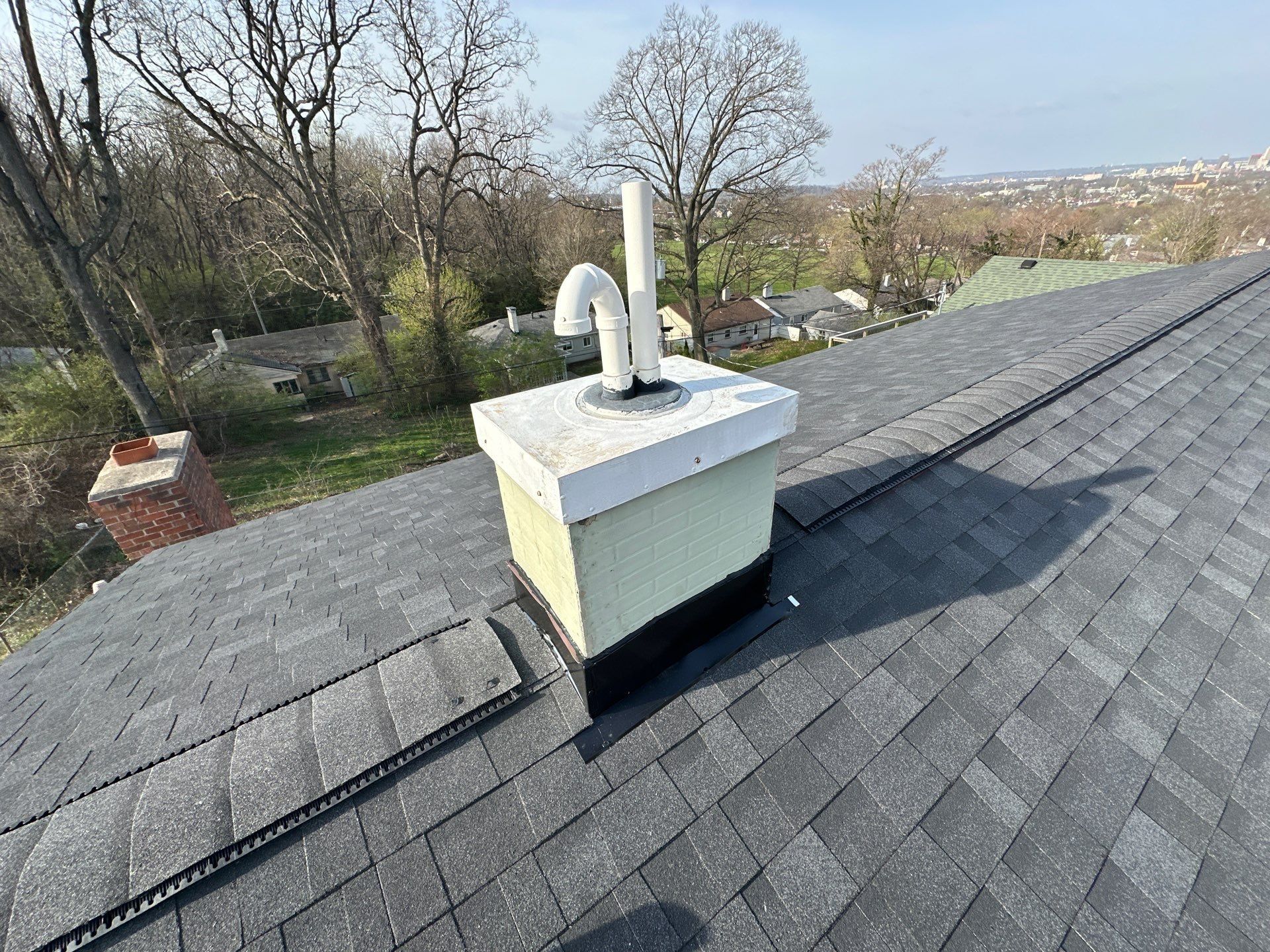 The flashed faux chimney and ridge vent, with the city beyond, Dayton, Ohio.