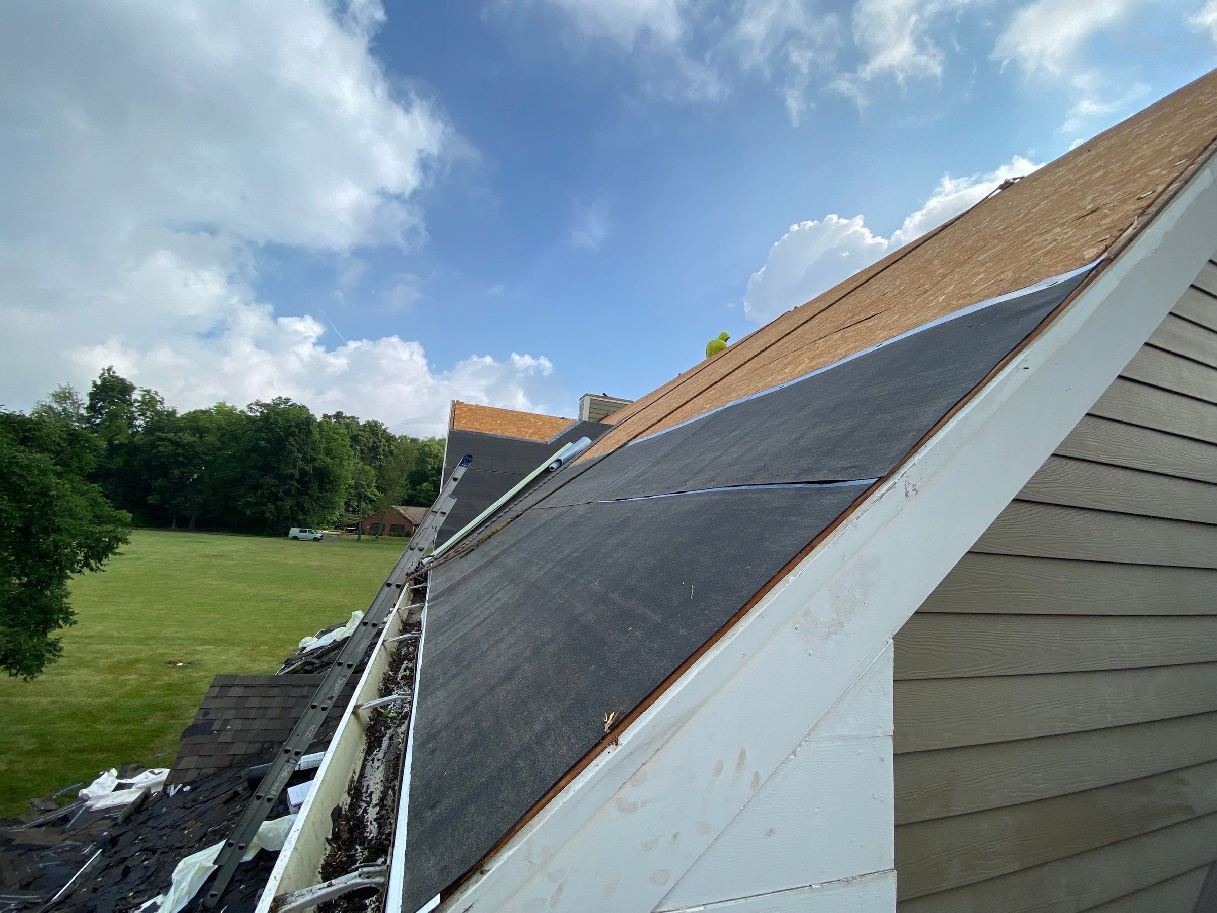 Dark underlayment rolled out along the lower eave of the upper roof, Yellow Springs, Ohio.