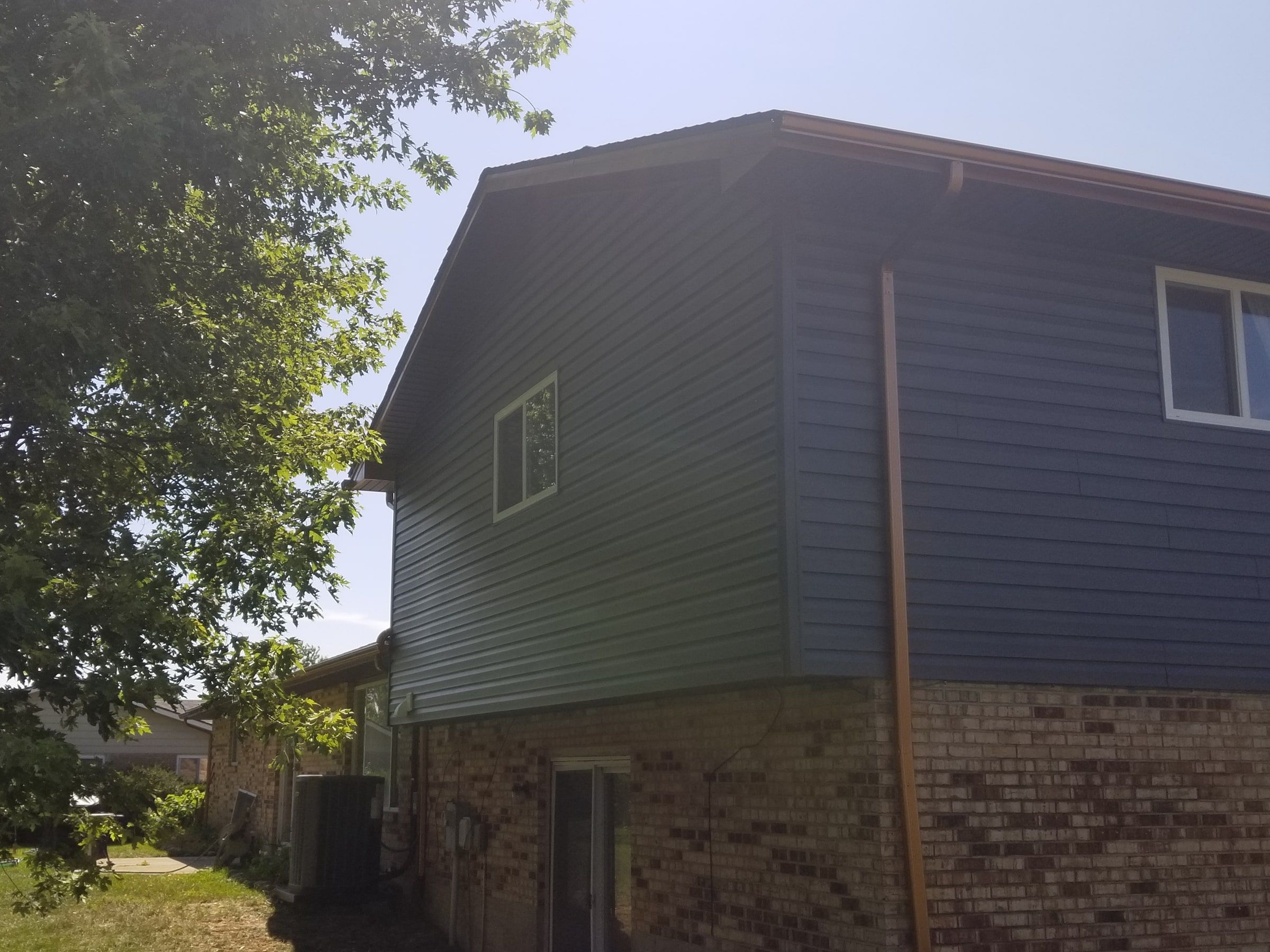 The side of the upper story with its copper-colored downspout, Beavercreek, Ohio.
