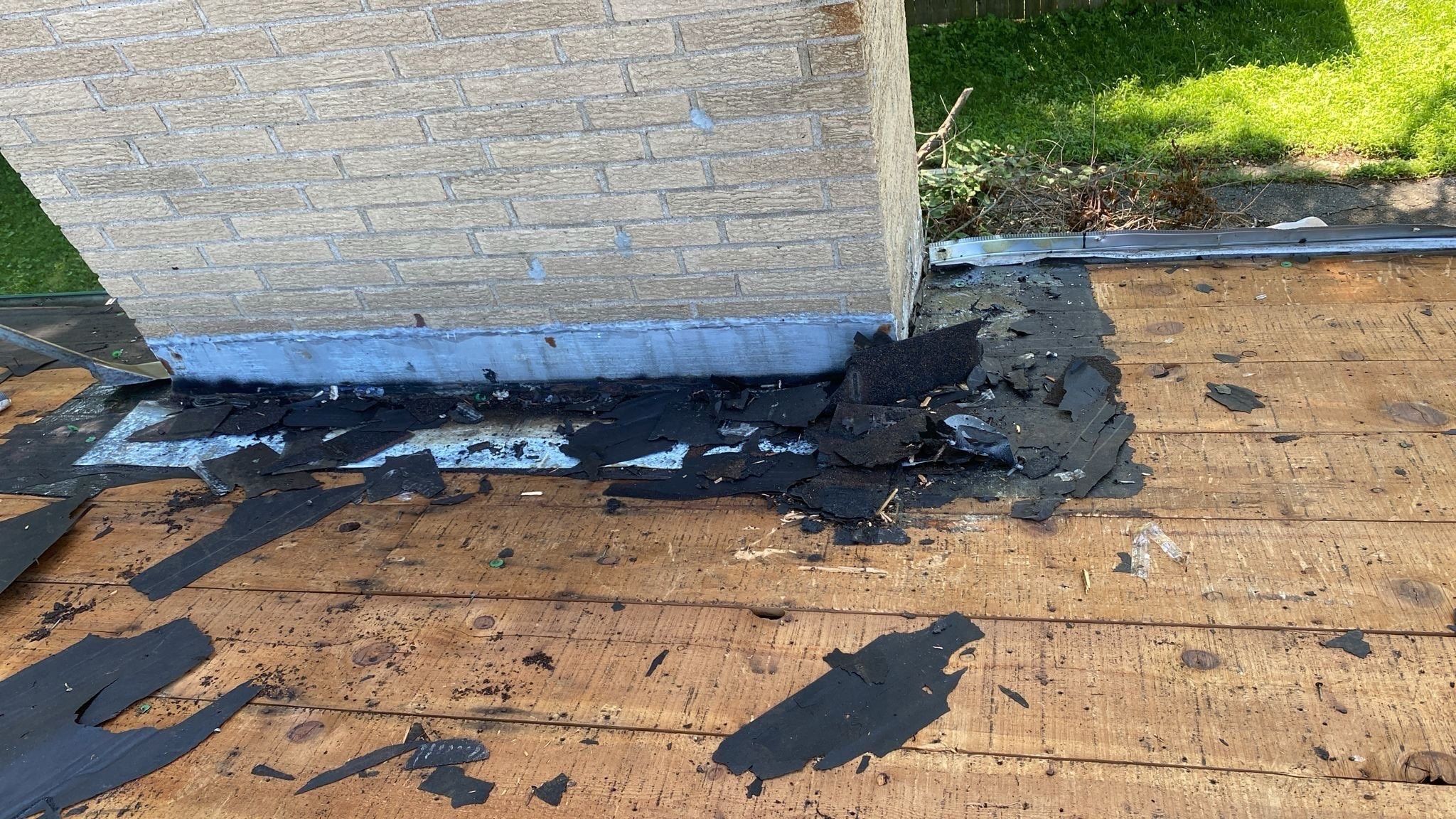 Chimney base cleared of old shingles and flashing during tear off, Beavercreek, Ohio.