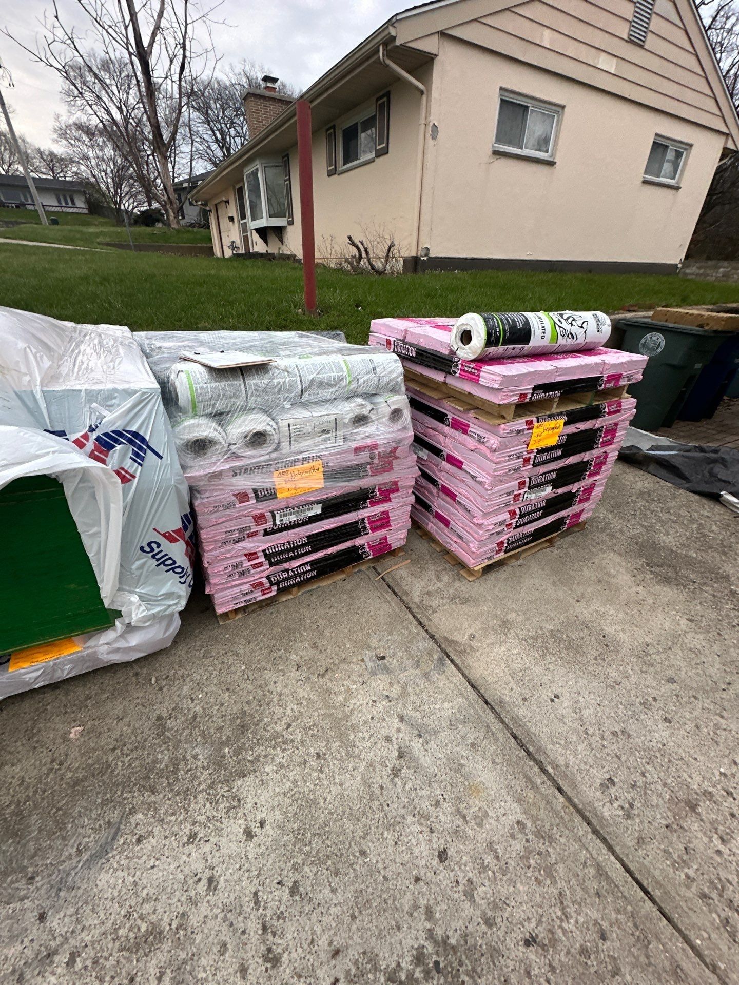 Shingle pallets, underlayment rolls and sheathing on the driveway, Dayton, Ohio.