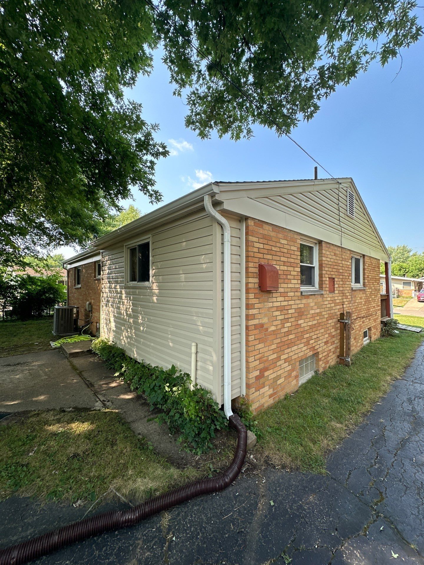 New white seamless gutter and downspout along the side of the house, Kettering, Ohio.