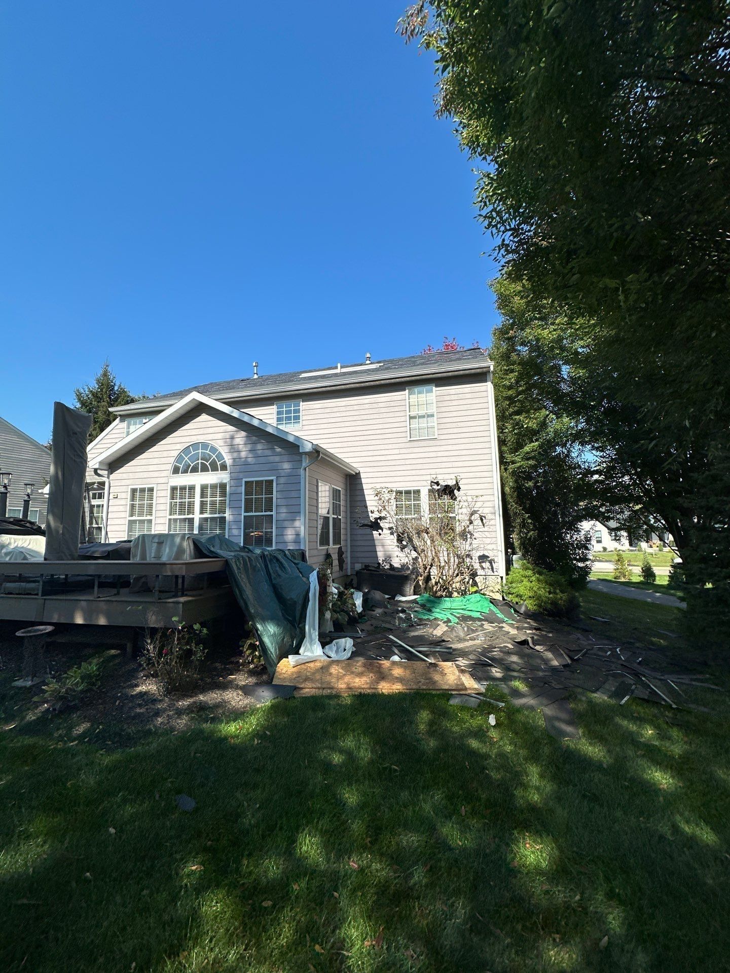 The back yard during the tear-off, with tarps below the roof, Beavercreek, Ohio.