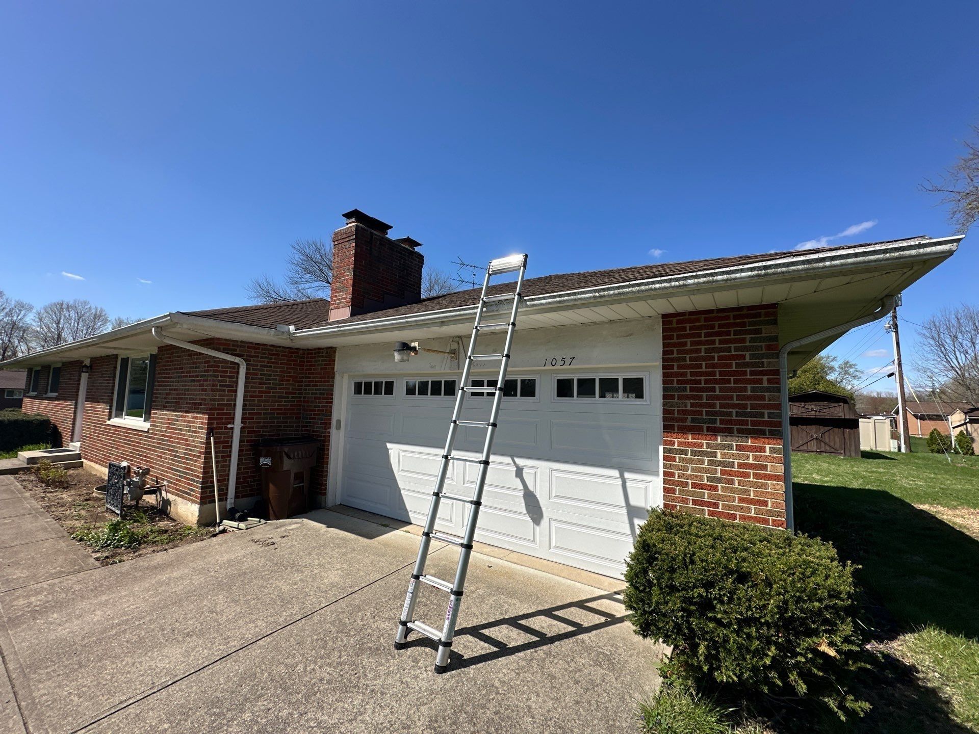 Ladder set against the garage eave for the roof inspection, Beavercreek, Ohio.