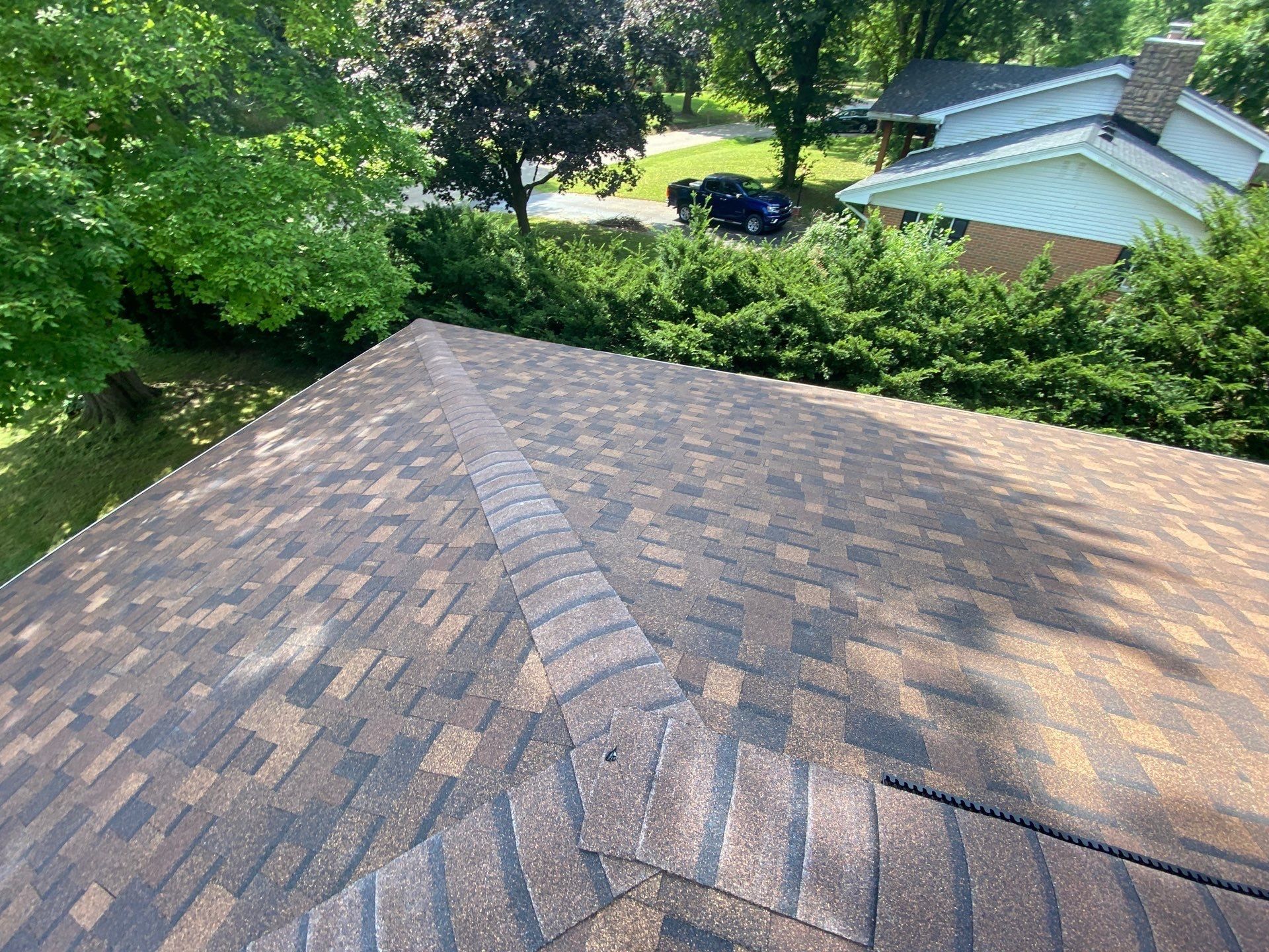 New shingles and hip cap on the slope facing the side yard, Beavercreek, Ohio.
