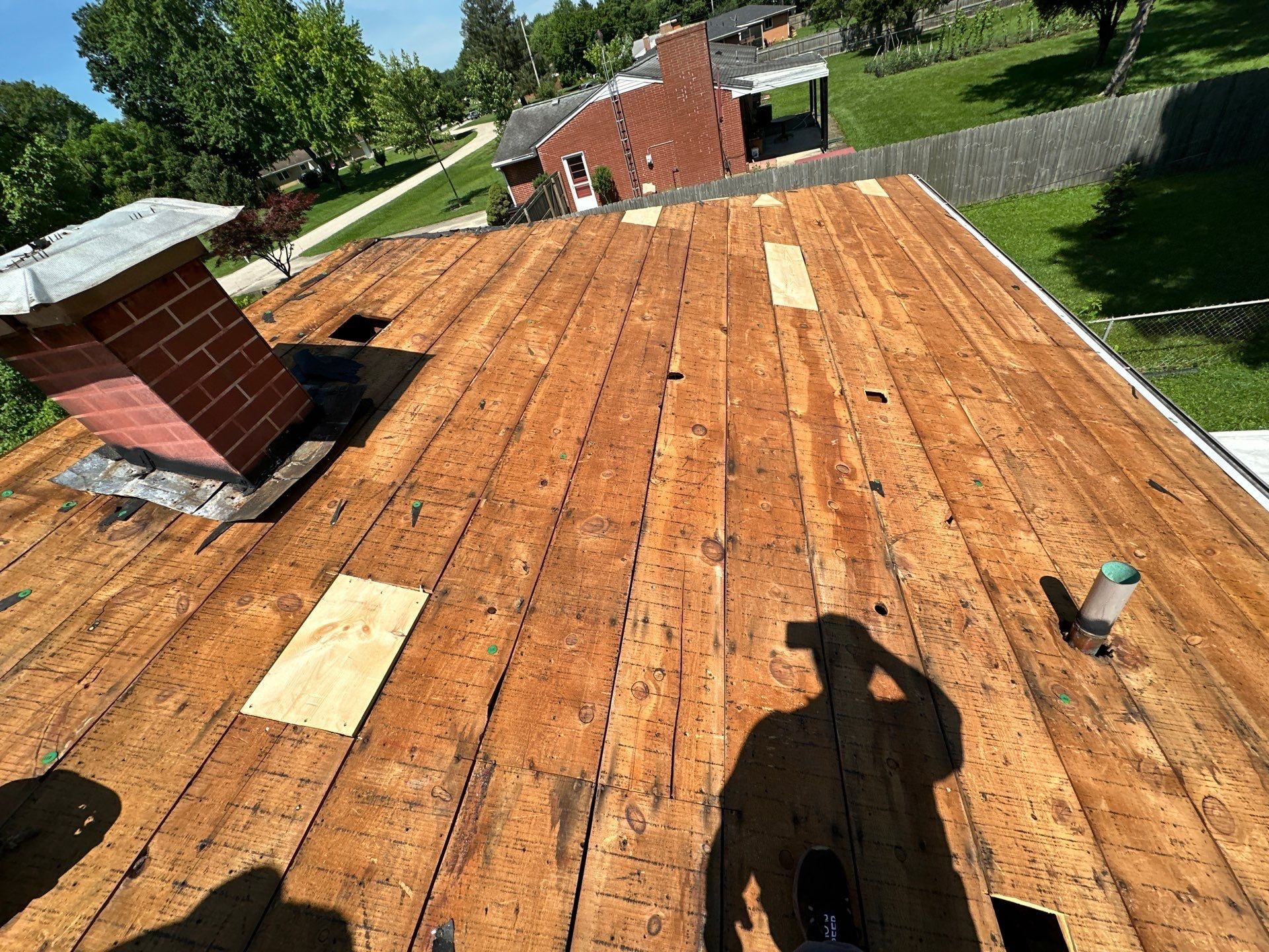 Fresh wood patches set into the board deck near the brick chimney, Beavercreek, Ohio.