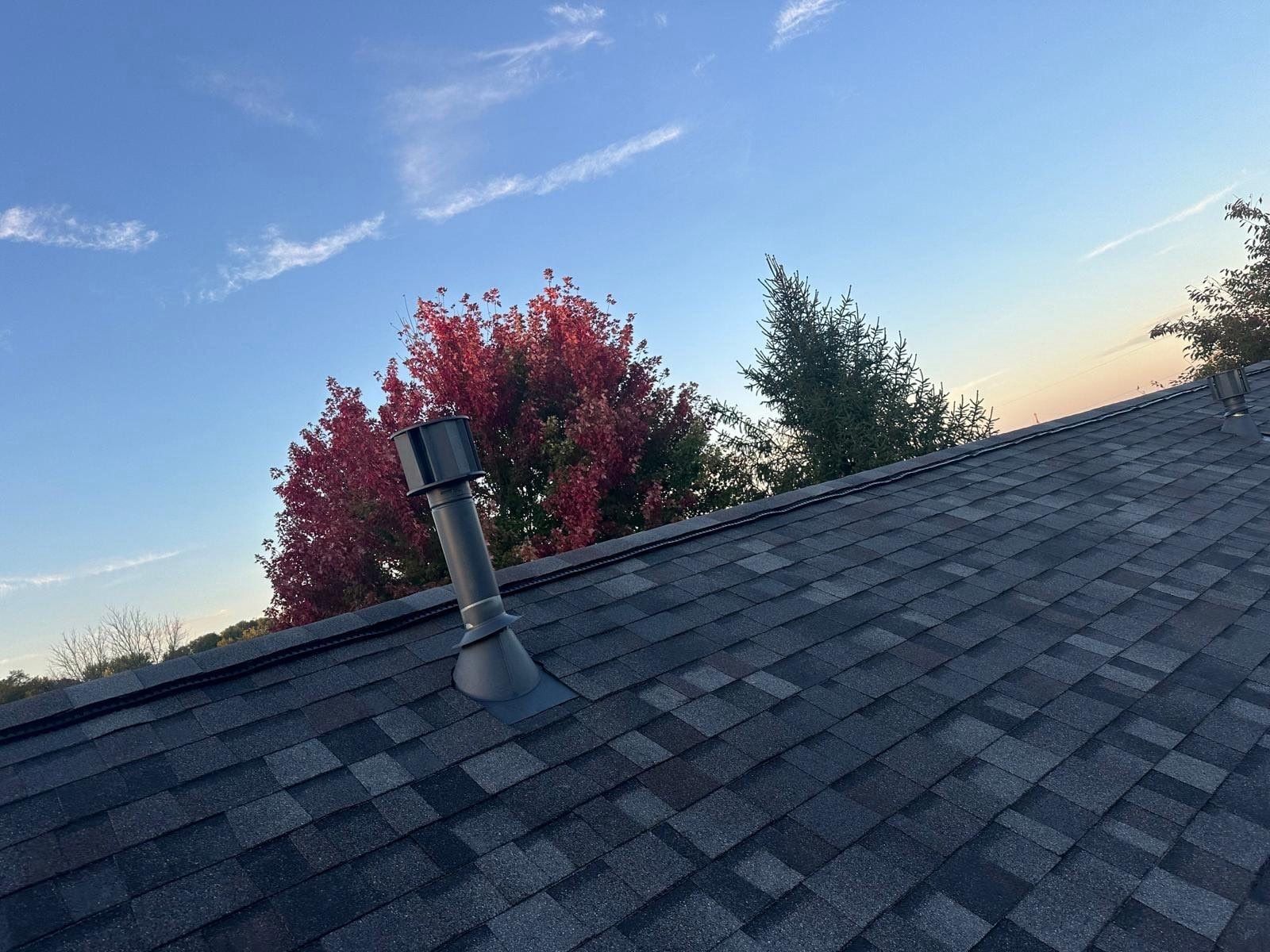 A new vent pipe boot on the finished shingles beside a red maple, Beavercreek, Ohio.