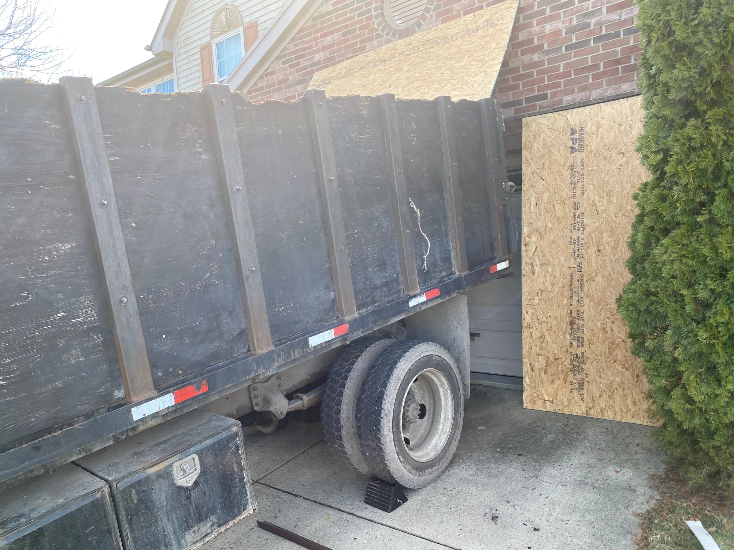 Dump trailer and plywood at the garage