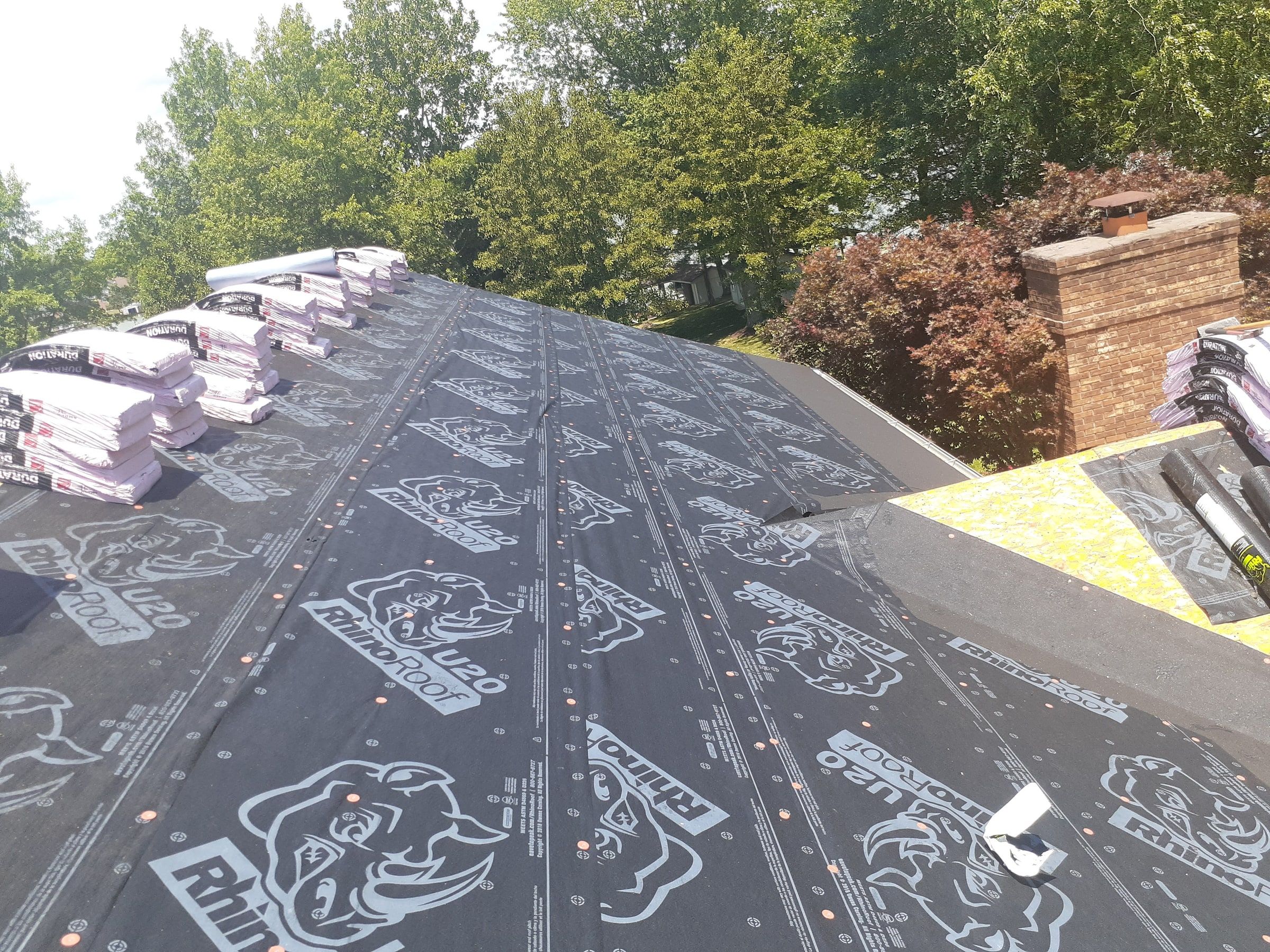 Underlayment running toward the chimney with bundles staged on top, Jamestown, Ohio.