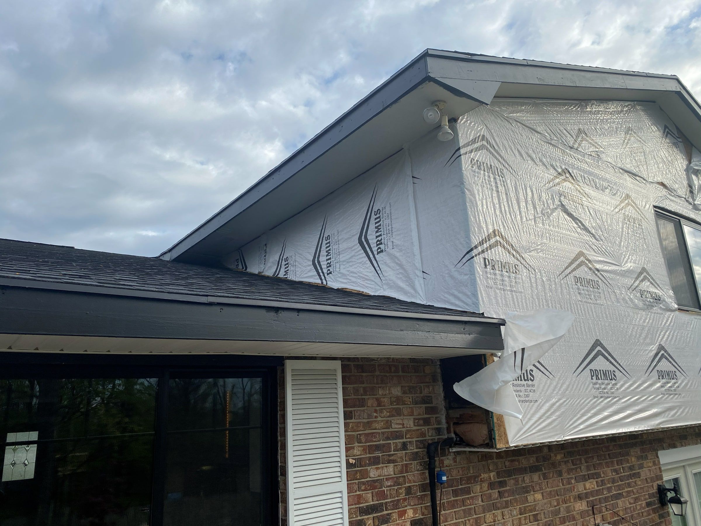House wrap above the lower roof at the back corner, Beavercreek, Ohio.