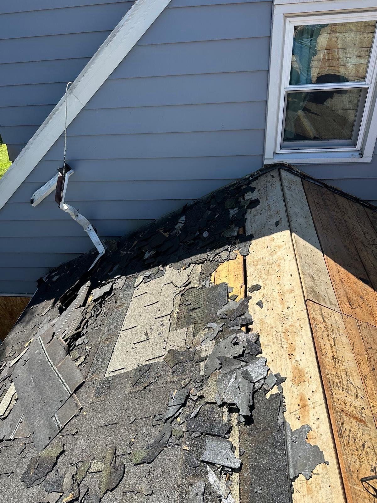 Old layers of shingles at the roof edge, peeled back from the deck, Beavercreek, Ohio.