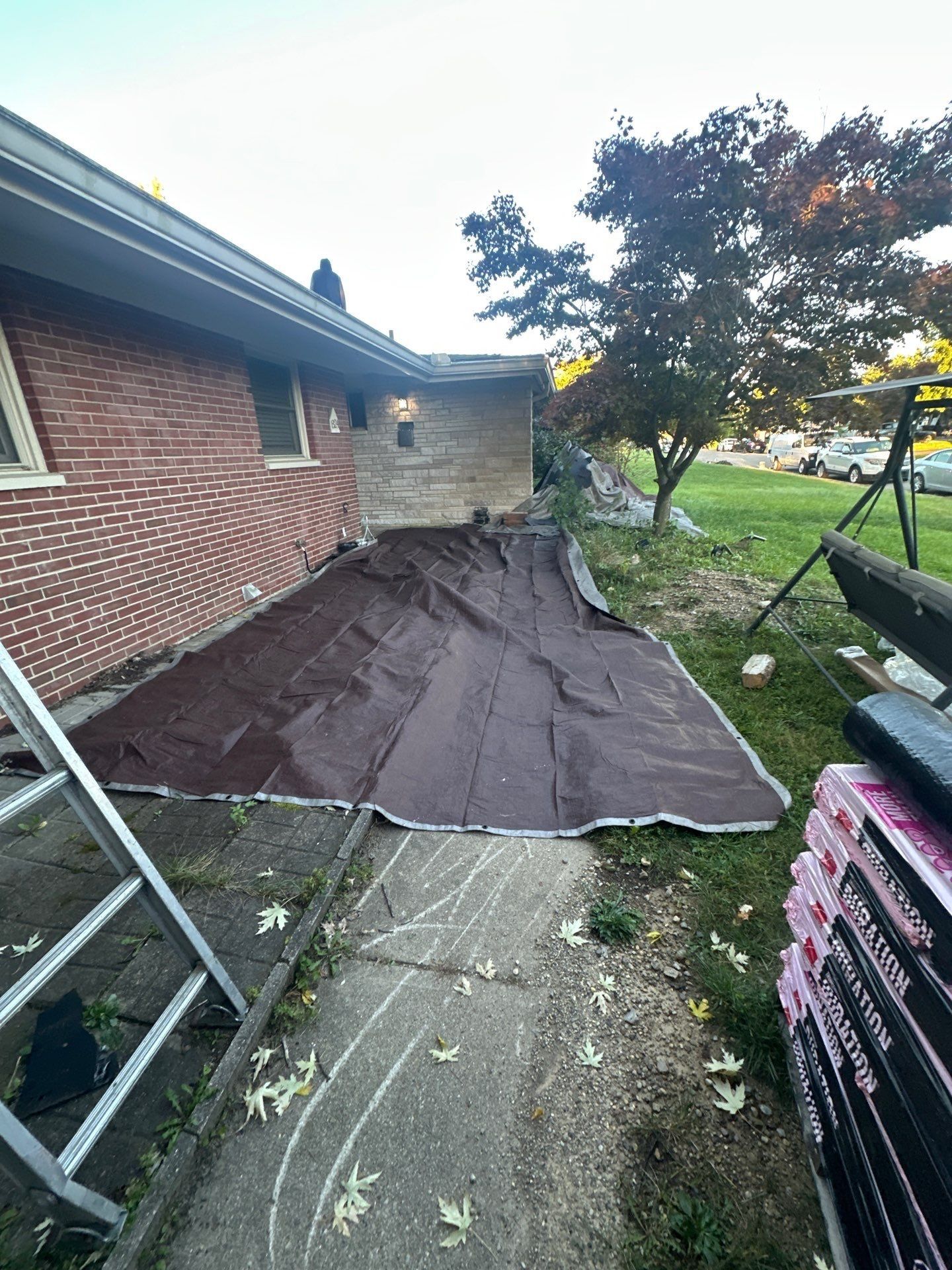 A brown tarp along the side of the house over the walk, Kettering, Ohio.