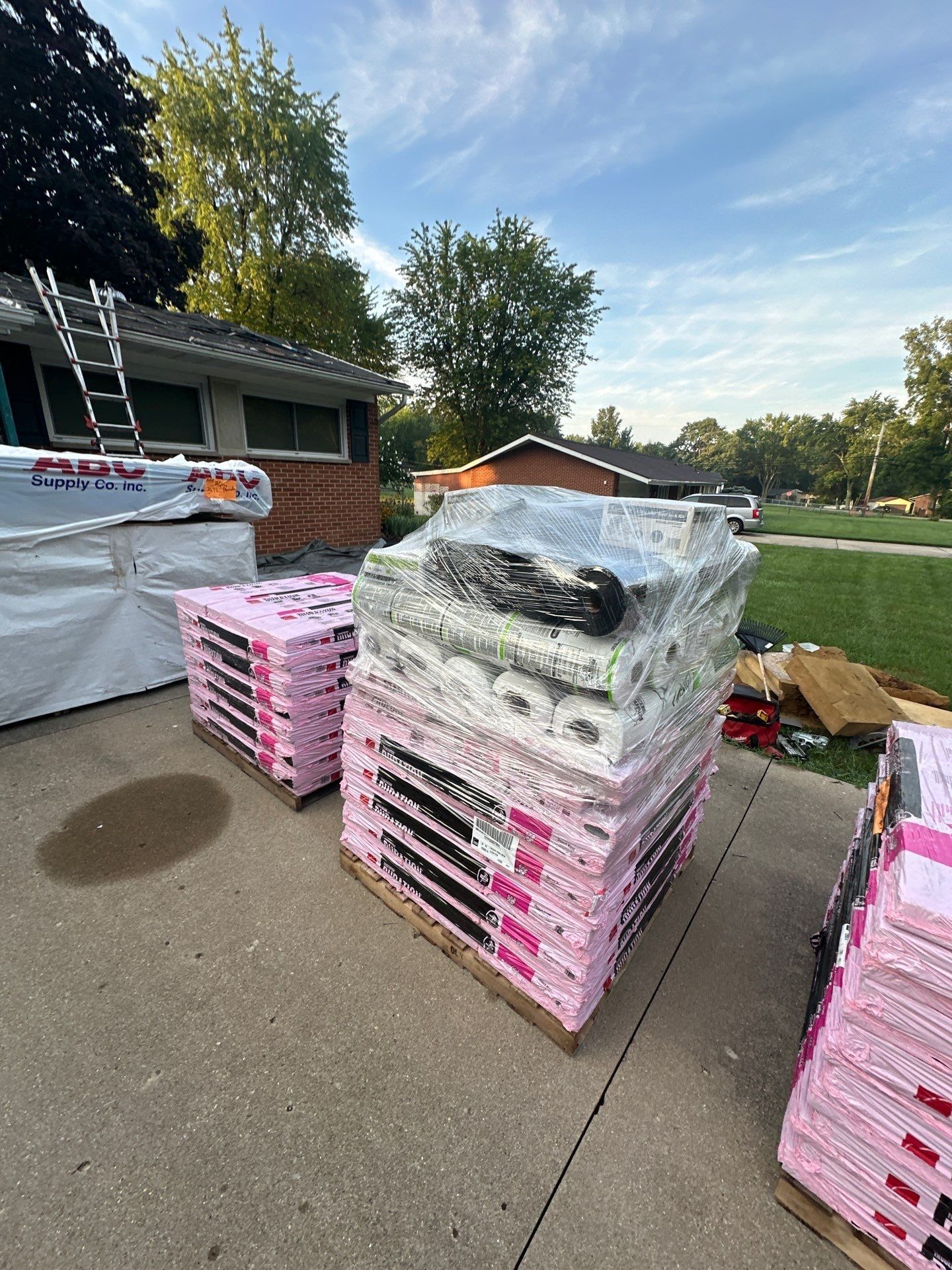 Shingle pallets, underlayment rolls and supply boxes stacked on the driveway, Beavercreek, Ohio.
