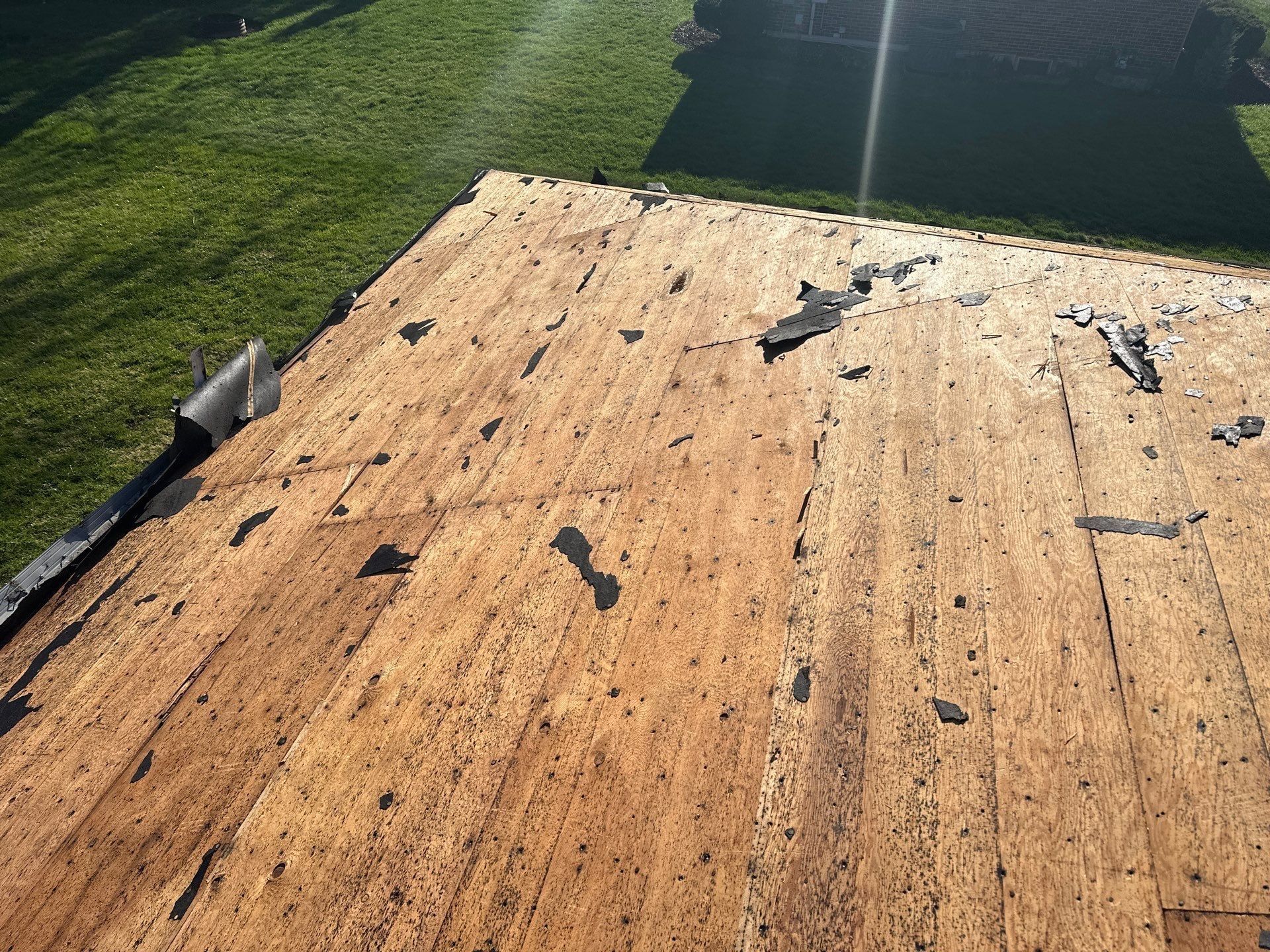 Bare wood roof deck with scraps of old roofing left after tear-off, Beavercreek, Ohio.