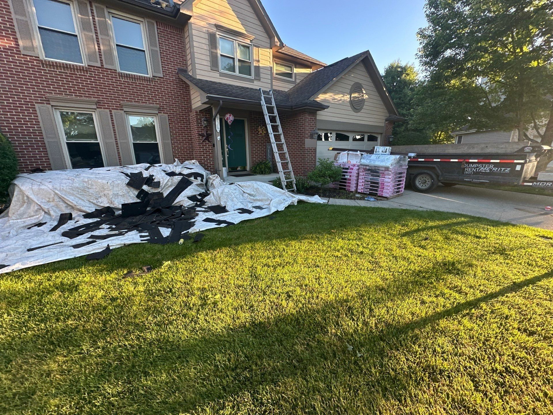 Tarps covering the front landscaping to catch old shingles during tear-off, Beavercreek, Ohio.