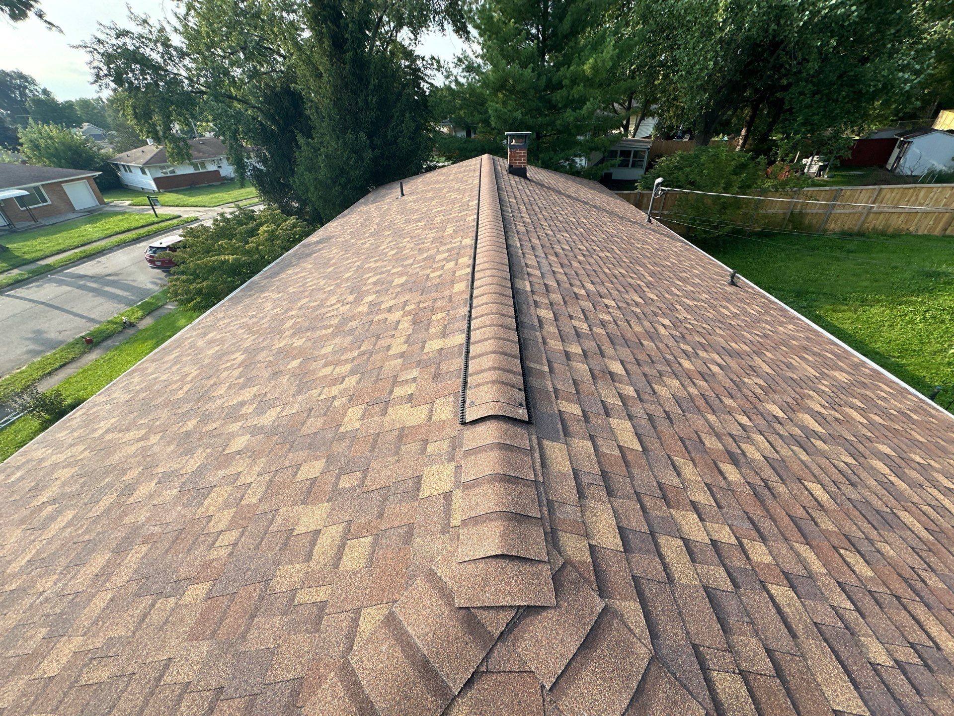 The finished roof and ridge cap running toward the brick chimney, Fairborn, Ohio.