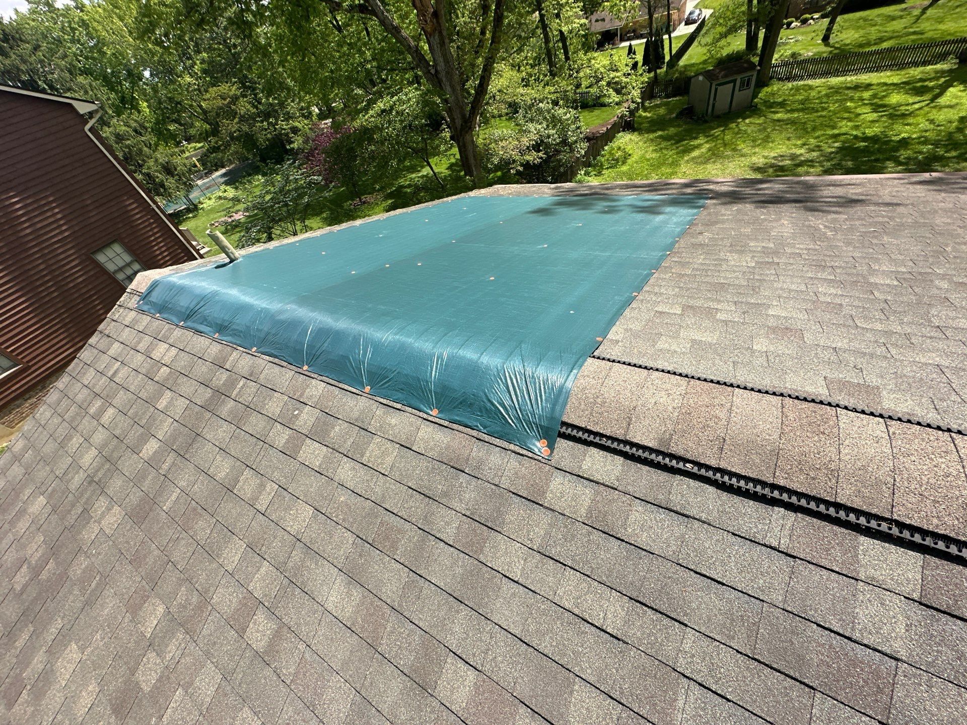 Teal tarp over one roof plane