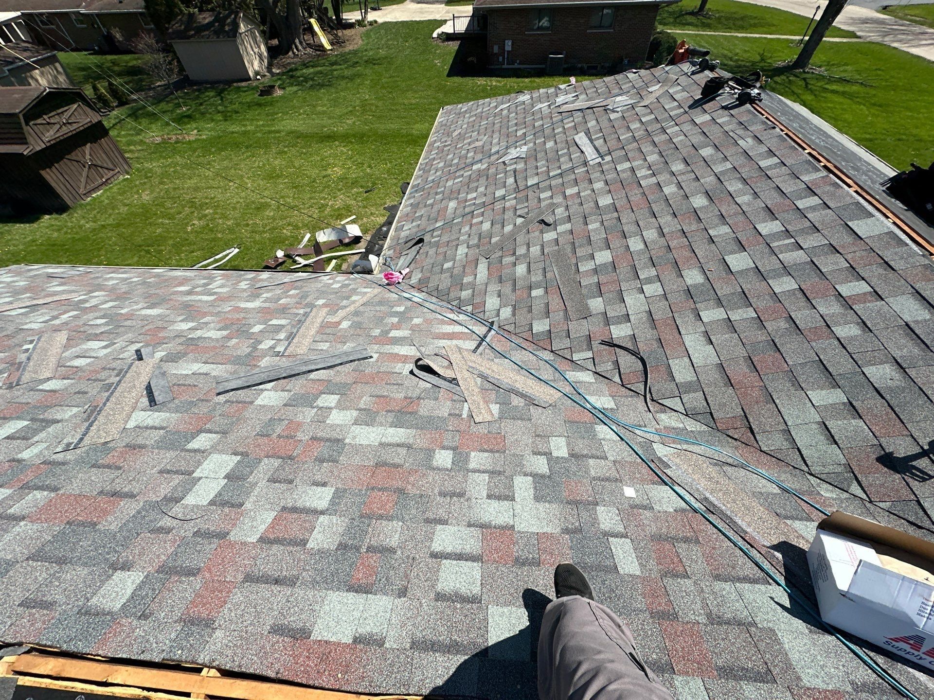 Fresh shingles meeting at a valley with cut pieces still on the roof, Beavercreek, Ohio.